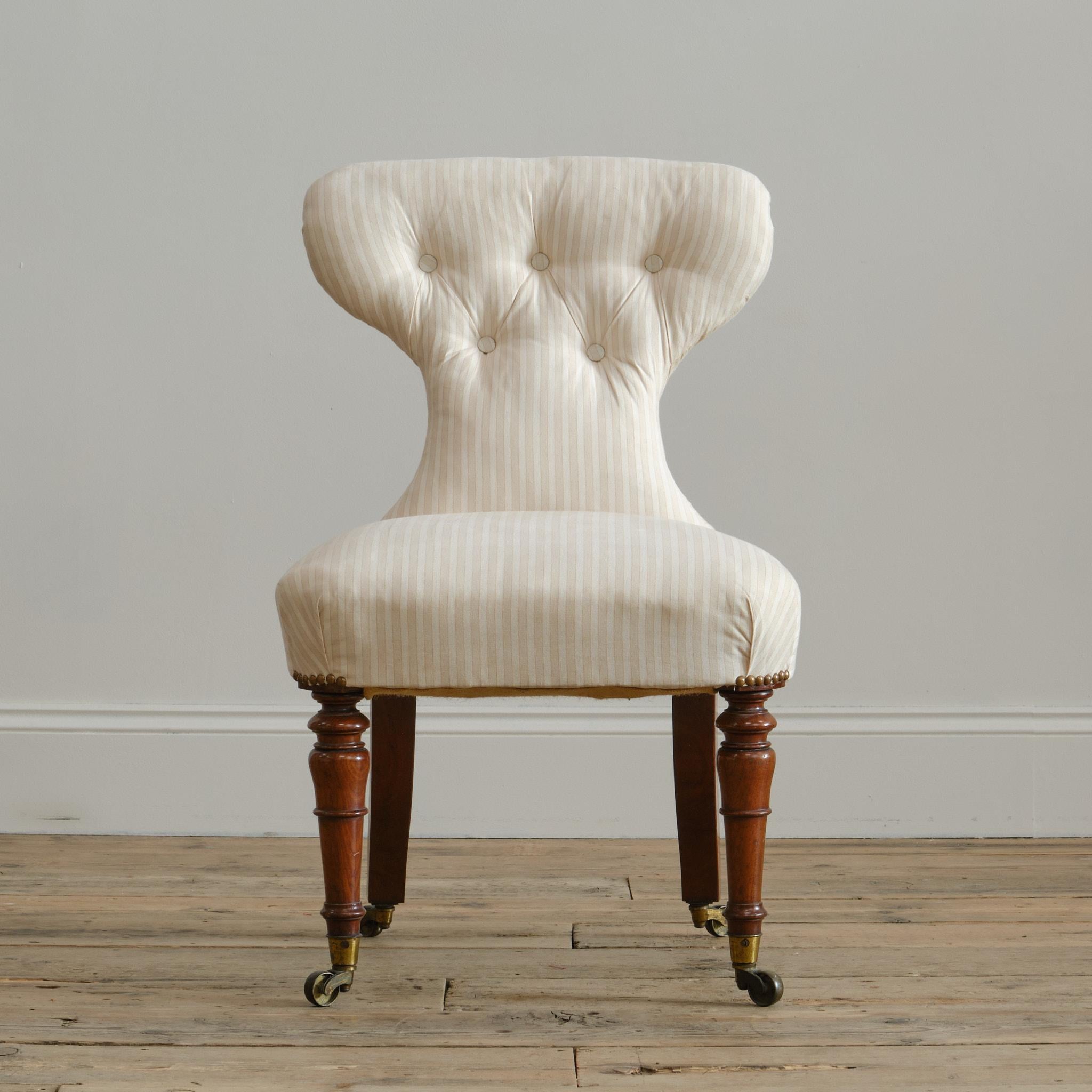 Silla de dormitorio o auxiliar de buena calidad de mediados del siglo XIX atribuida a Holland & Sons. Levantada sobre altas patas delanteras torneadas de caoba, con las traseras ensanchadas hacia fuera y todas con las ruedas originales de latón.