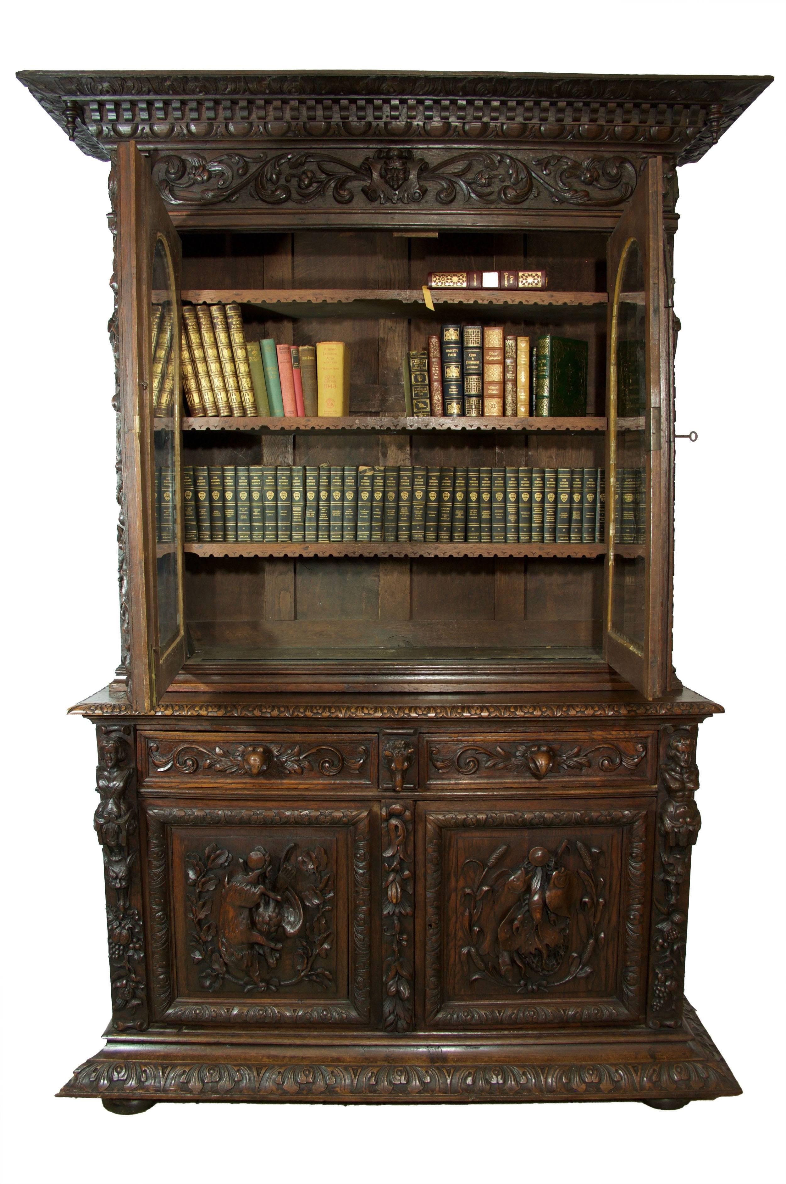 German-made. The bookcase is over a two-drawer and two-door cabinet. Carving is exemplary, evidences an artisan of master skill level. Bird's beak drawer handles are unique.