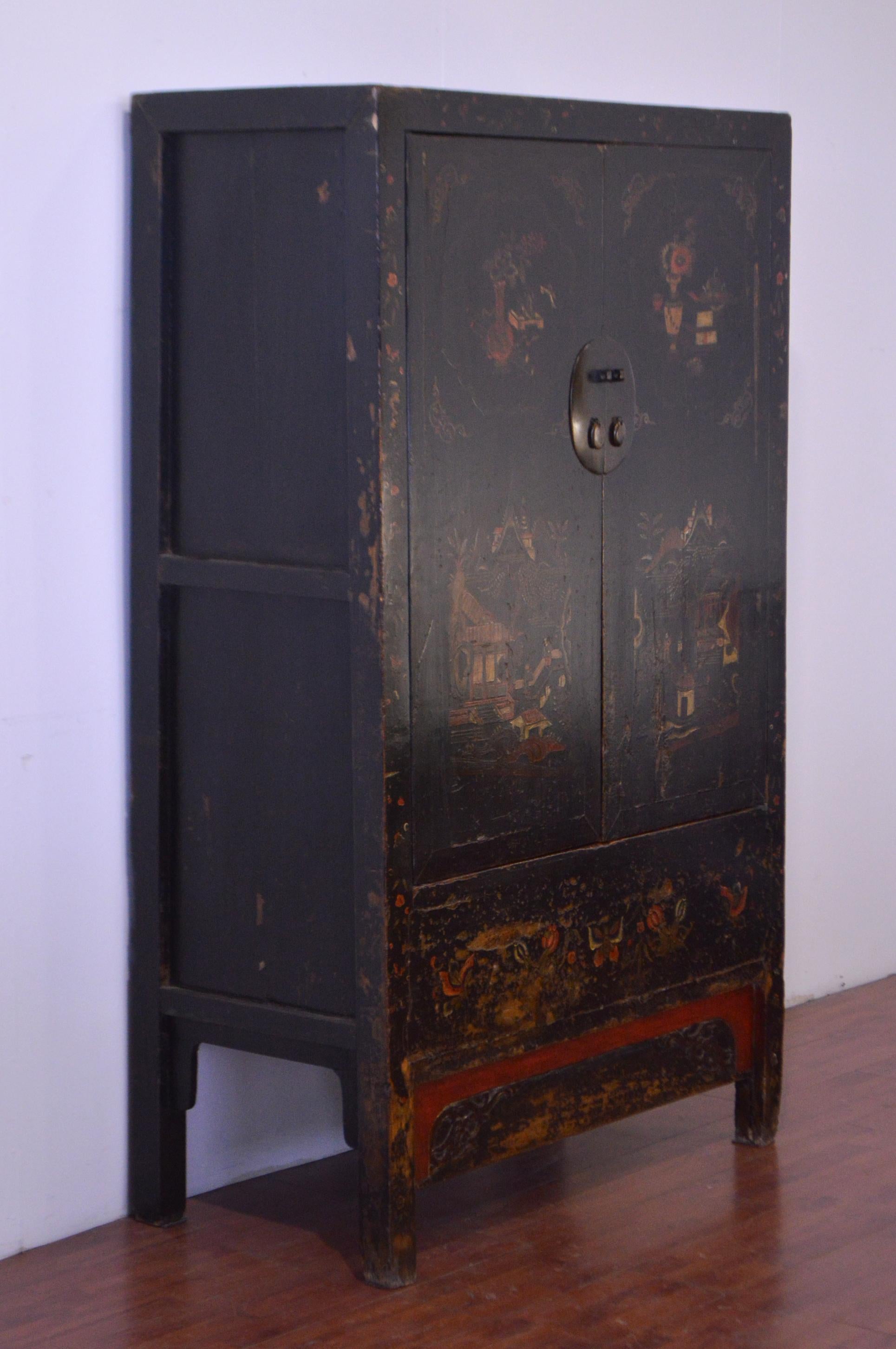 Old and elegant black lacquered Chinese cabinet in elm from the mid 19th century. 
The hand-forged iron hardware is clearly visible and the two doors that offer access to spacious interior show hand painted drawings: beautiful floral motifs, symbol