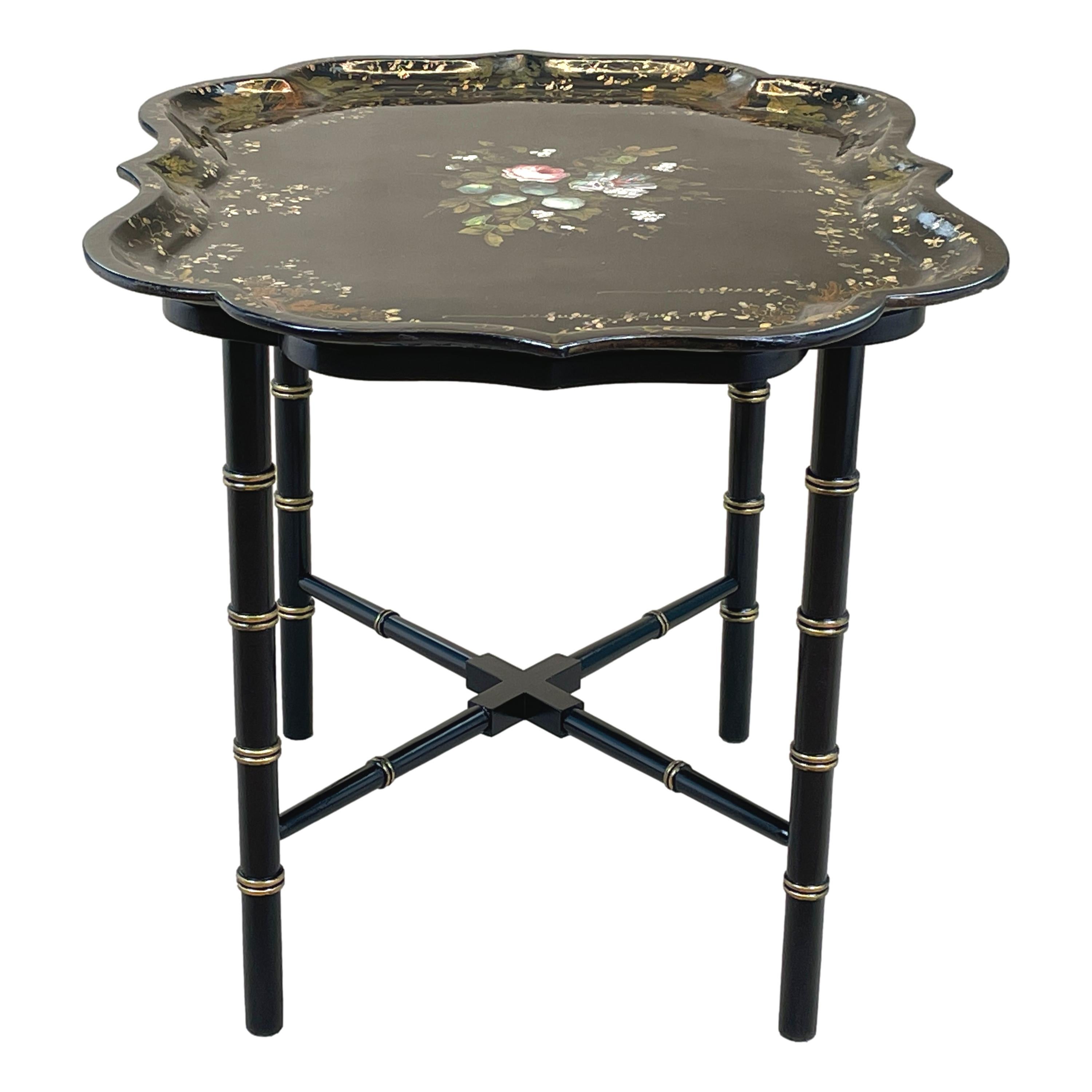 A very attractive mid 19th century black laquered
Shaped papier mache tray with elegant painted &
Gilded decoration housed on later faux stand
With faux bamboo design legs & cross stretcher

(What better way to look after the environment than