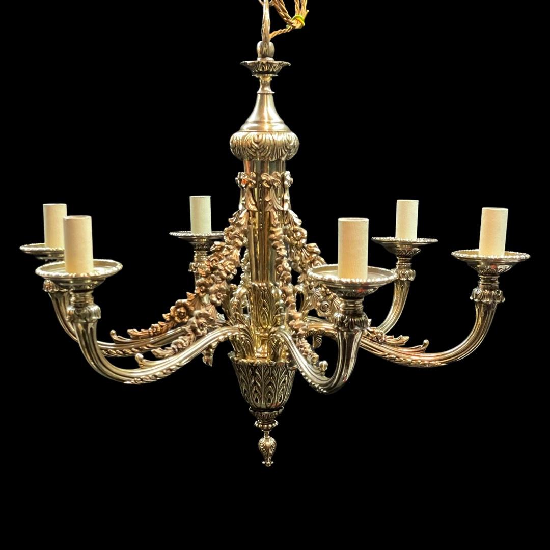 This chandelier is a stunning piece that would add a touch of luxury to any space. With its intricate hand-chased detailing and six arms, it has a classic design that's both elegant and timeless. Made from solid brass and dating back to the mid-19th