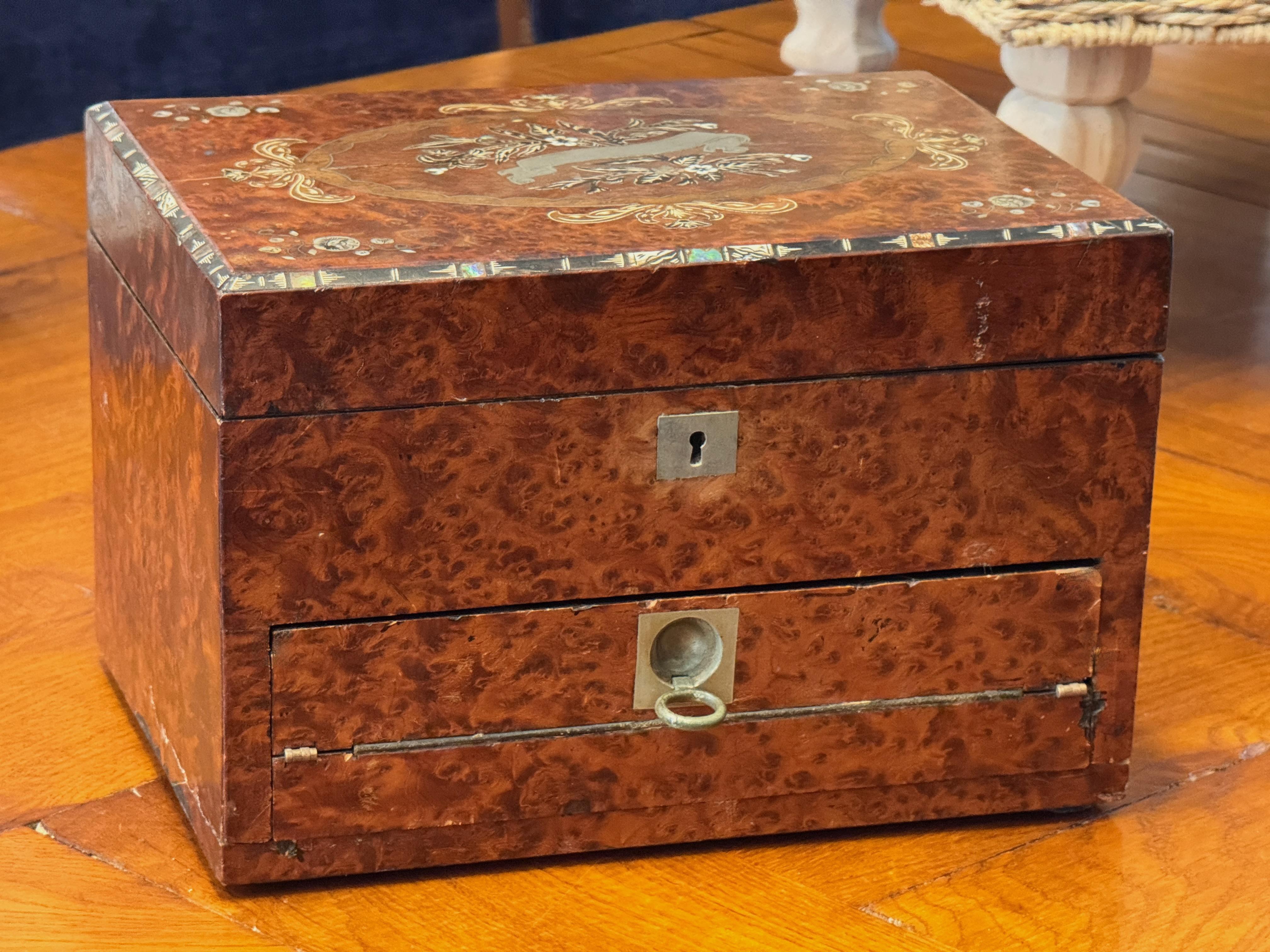 Rare boîte à bijoux de voyage de l'Empire britannique, fabriquée en Angleterre vers 1840. L'extérieur est richement plaqué de bois d'if et d'amboyna, appréciés pour leur figuration profonde et leur chaleur. Le couvercle et la façade sont richement