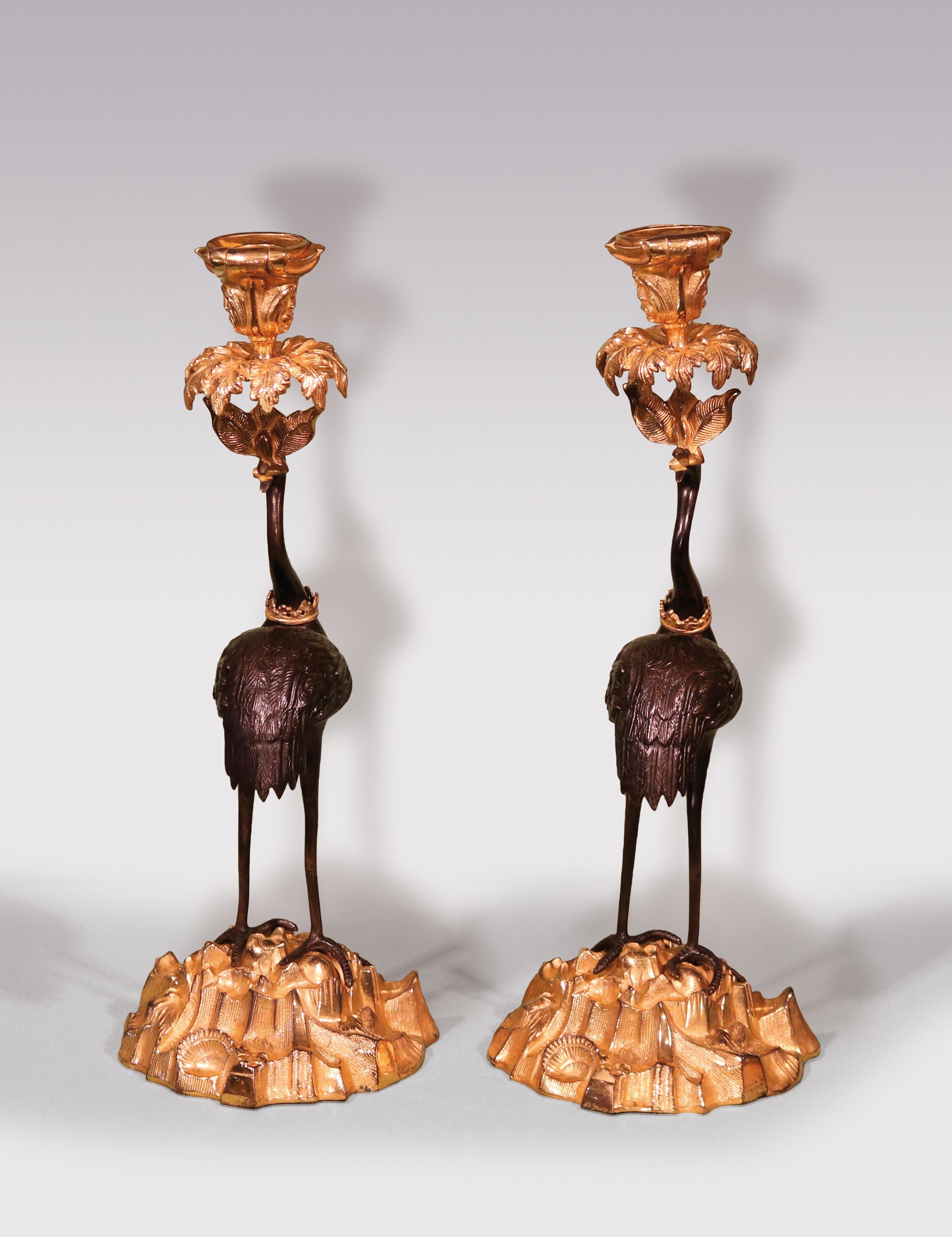 An unusual pair of mid-19th century bronze and ormolu candlesticks, having Rococo candleholders above well cast storks with distinctive crowns to their necks, raised on rock and shell bases. (Cast iron bases stamped Abbott)
circa 1850.