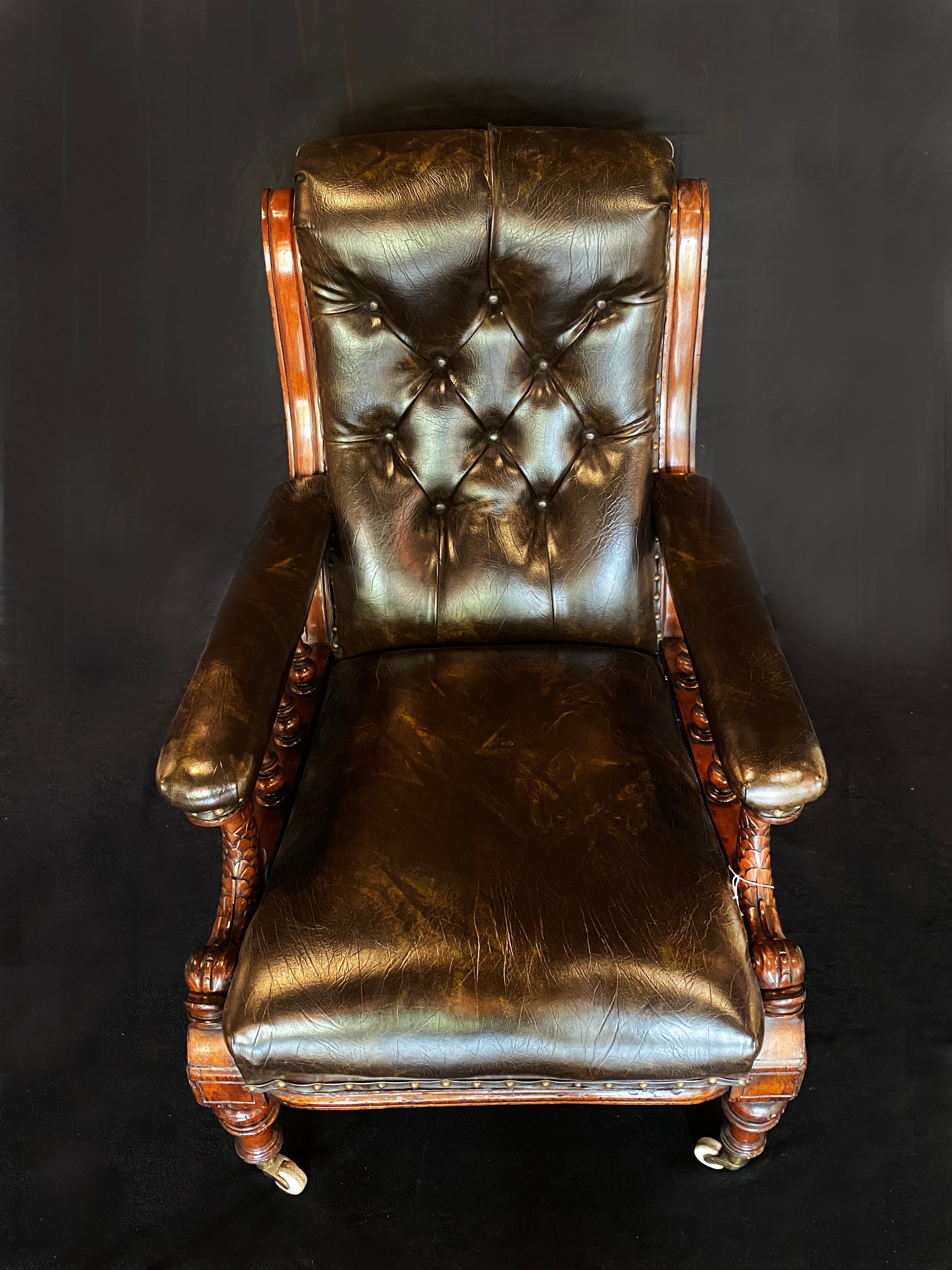 Mid 19th century mahogany leather library armchair. The button down deep brownleather is in perfect condition and luxurious to touch. The mahogany carved fish arms provide superb intricate detail, supported by three turned baulsters. The baulster
