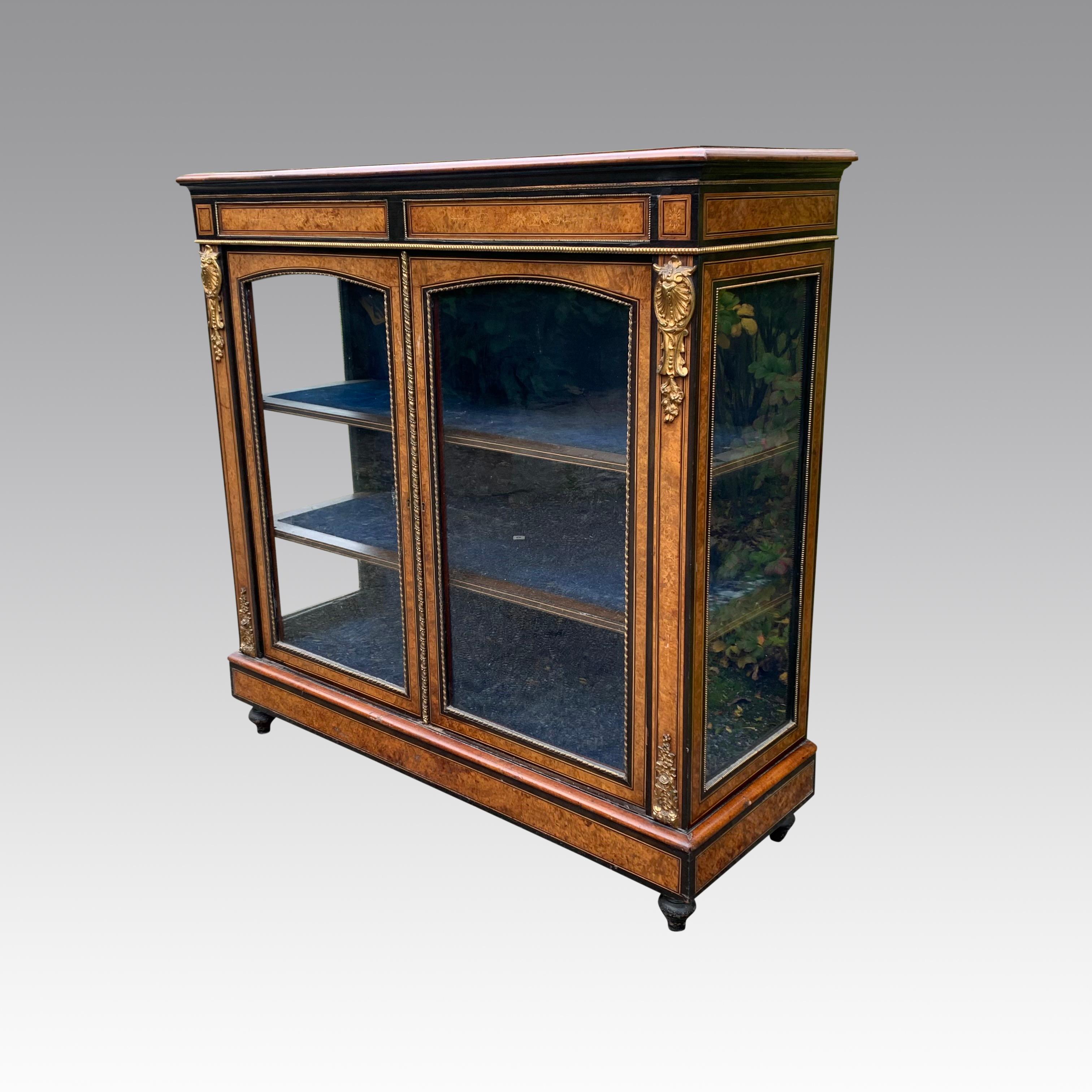 A superb quality mid 19th century walnut and inlaid side cabinet with glazed doors and sides. The ebonised top double crossbanded in burr walnut above an inlaid freize and arched glazed doors flanked by inlaid and ormolu mounted pilasters, standing