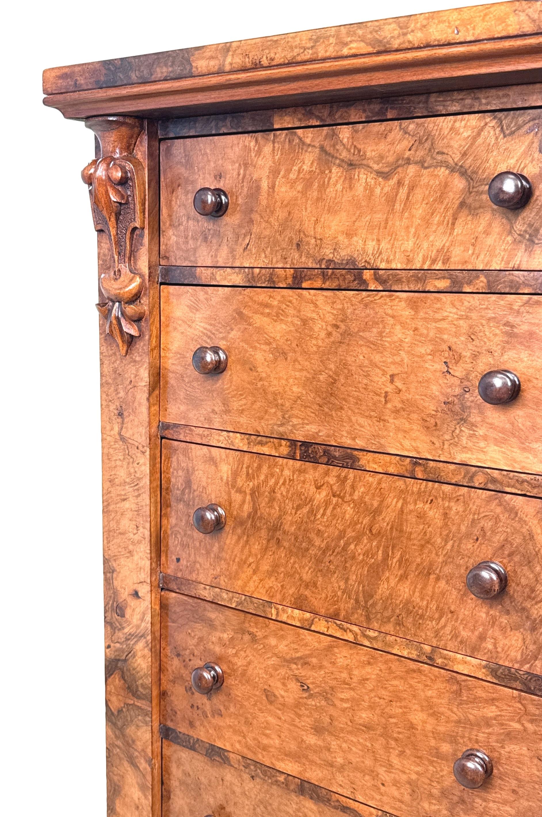 Arcón Wellington de nogal del siglo XIX, de muy buena calidad, con chapas de madera magníficamente labradas por todas partes, la tapa rectangular sobre siete cajones con pomos de madera torneados en su mayor parte originales, flanqueados por