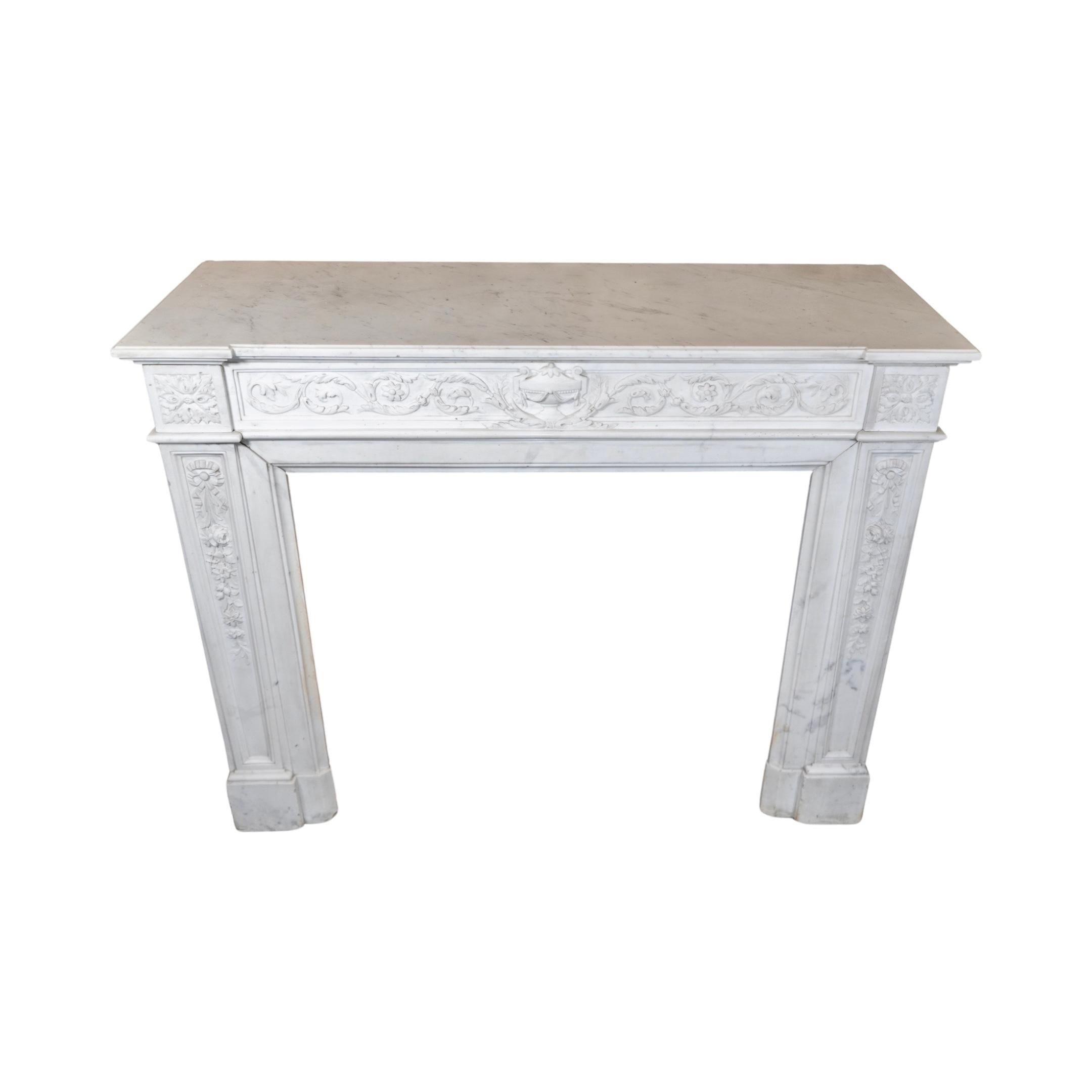 Crafted in France in 1860, this Carrara Marble Mantel exudes elegance and sophistication with its white veined marble and intricate floral motifs. The center features a stunning ventral urn vase, making it a beautiful addition to any home. Elevate