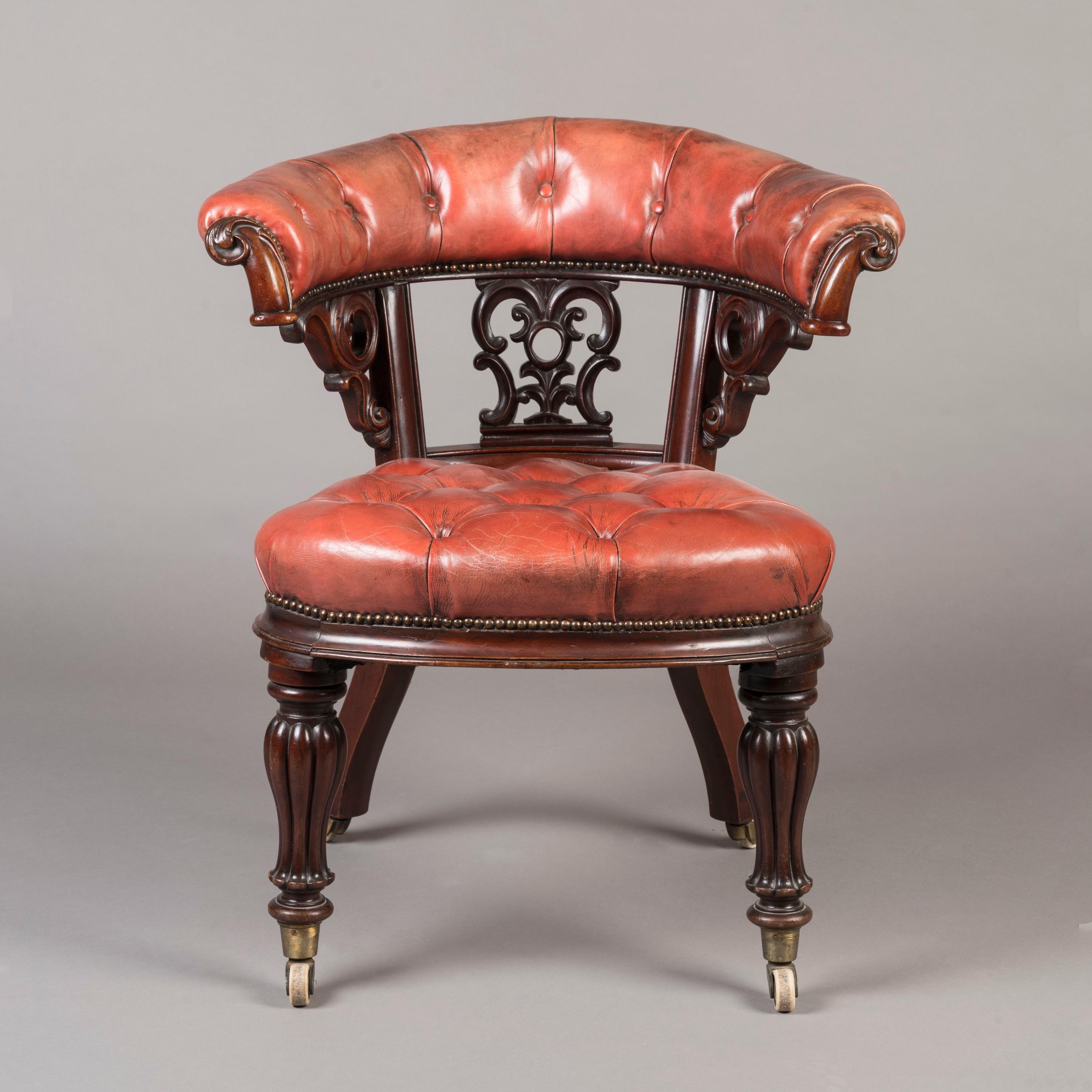 A Mid-19th Century Carved Mahogany Desk Chair

Constructed from solid carved mahogany, the chair standing on confidently lobed baluster front legs, with splayed legs to the rear, all with porcelain castors; the horseshoe-shaped back with pierced