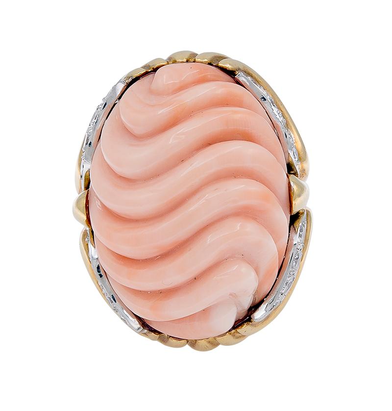 One Pink Coral Diamond 2-tone Gold Cocktail Ring. This ring features one huge pink coral with wavy carved design. This piece is accented by 16 round brilliant cut diamonds with a total weight of approximately 0.32 carats. Set in a 2-tone 18K