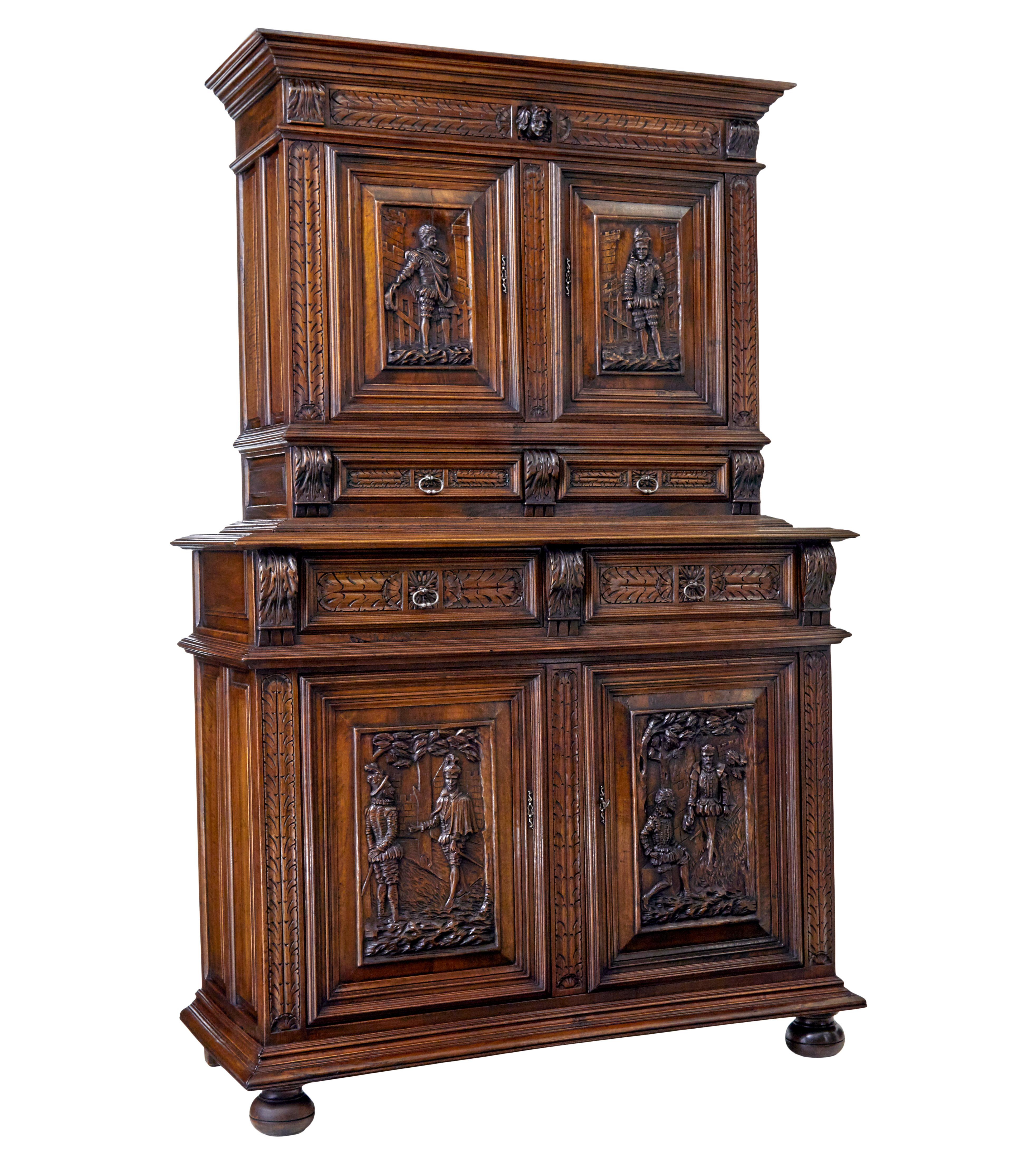 Good quality carved italian two part cabinet cupboard, circa 1850.

Beautifully carved in walnut, with good colour and patina.

Features four carved panels on the doors of Spanish gentlemen in 16th century dress, further carved decoration with