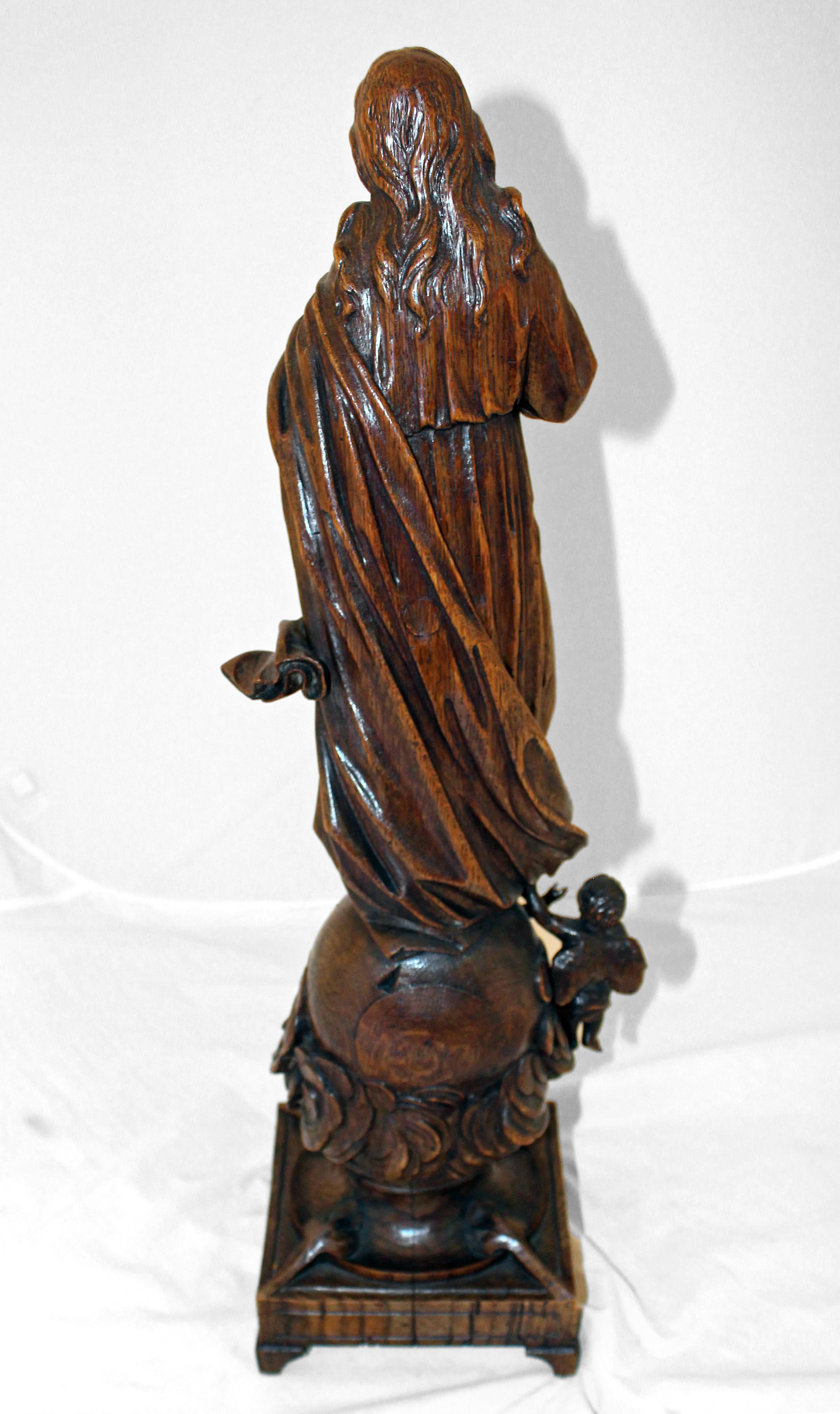 A fine mid-19th century carving of the Assumption of Mary into the heavens, standing on the world in cloud with angelic supporters (separately carved). Warm European white oak. Carved with sensitivity in a difficult medium.
23