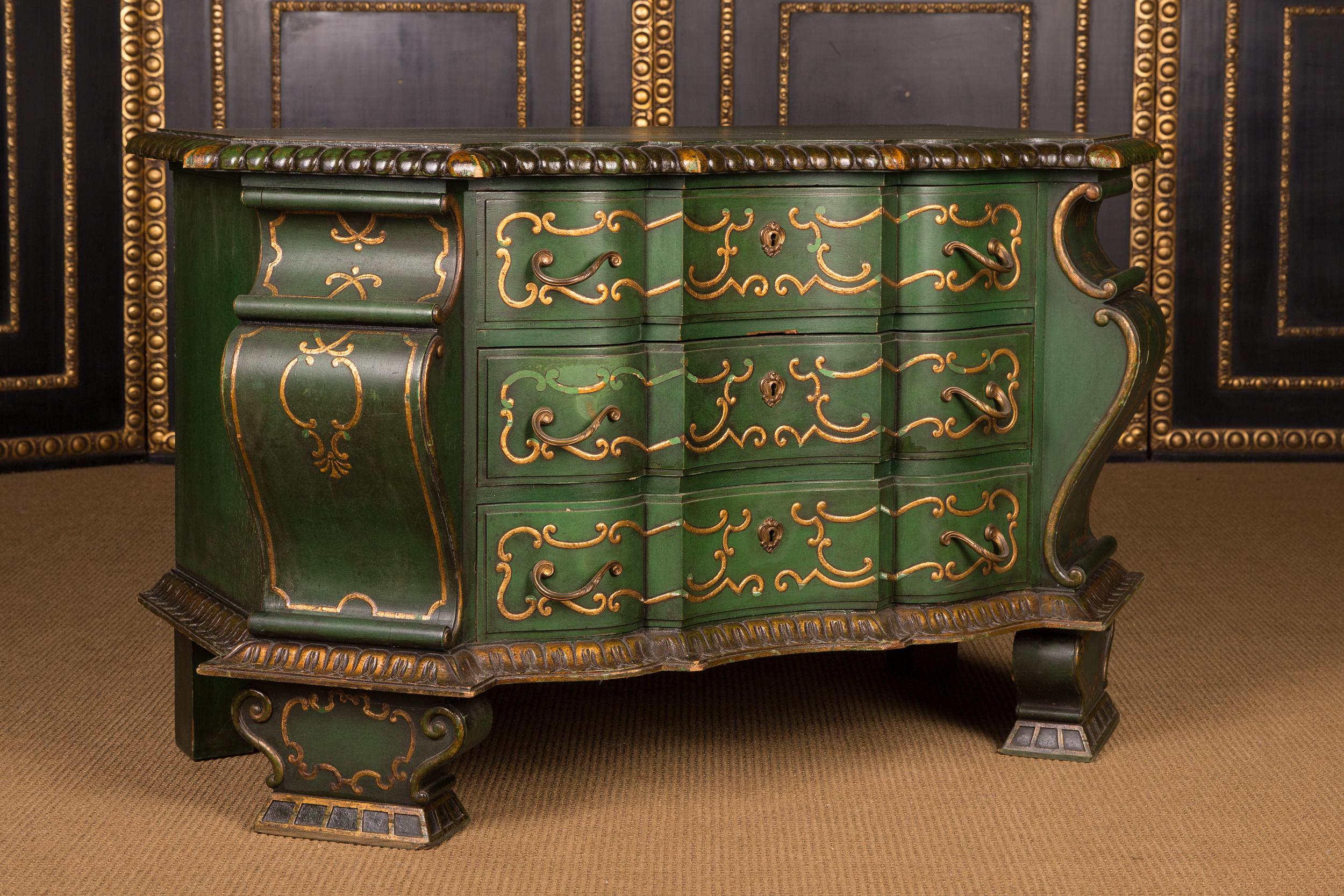 Solid wood painted in green. Profile-framed, reasonably curved frame on high, curved feet. In the multi-curved front three drawers with gold ornaments. Slightly protruding, properly curved, profile-framed cover plate.
Excellent, over decades grown