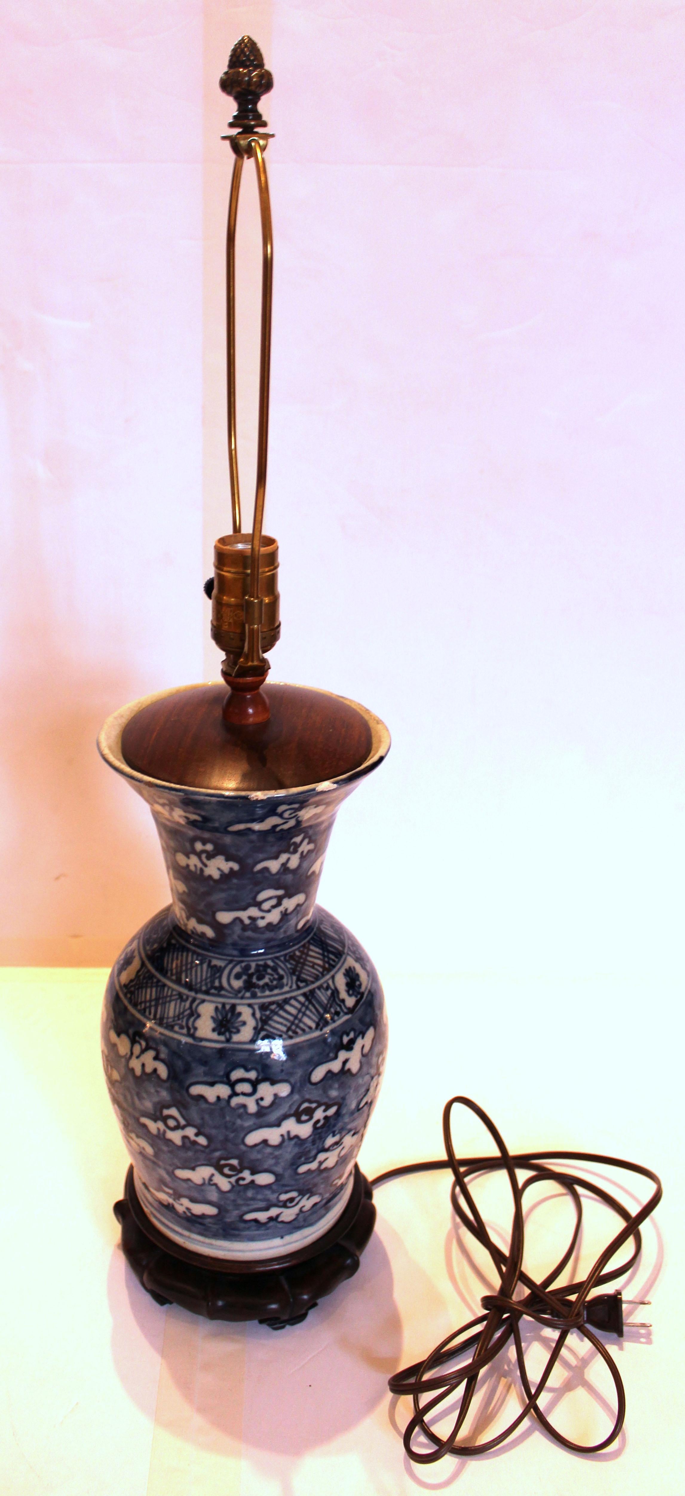 Lampe-vase chinoise bleu et blanc du milieu du 19e siècle. Le haut du vase en porcelaine de forme balustre présente des éclats mineurs et une zone restaurée, probablement la raison pour laquelle il a été transformé en lampe. Décor de nuages flottant