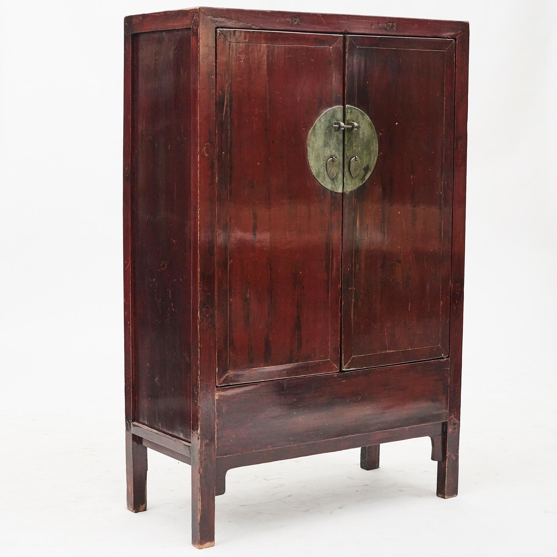 Lacquered wedding cabinet from Shanxi province, North China. Mid-19th century.
Features two doors, beautifully accented with a circular brass face plate.
Inside with shelves and drawers. Original red lacquer, beautiful patina.