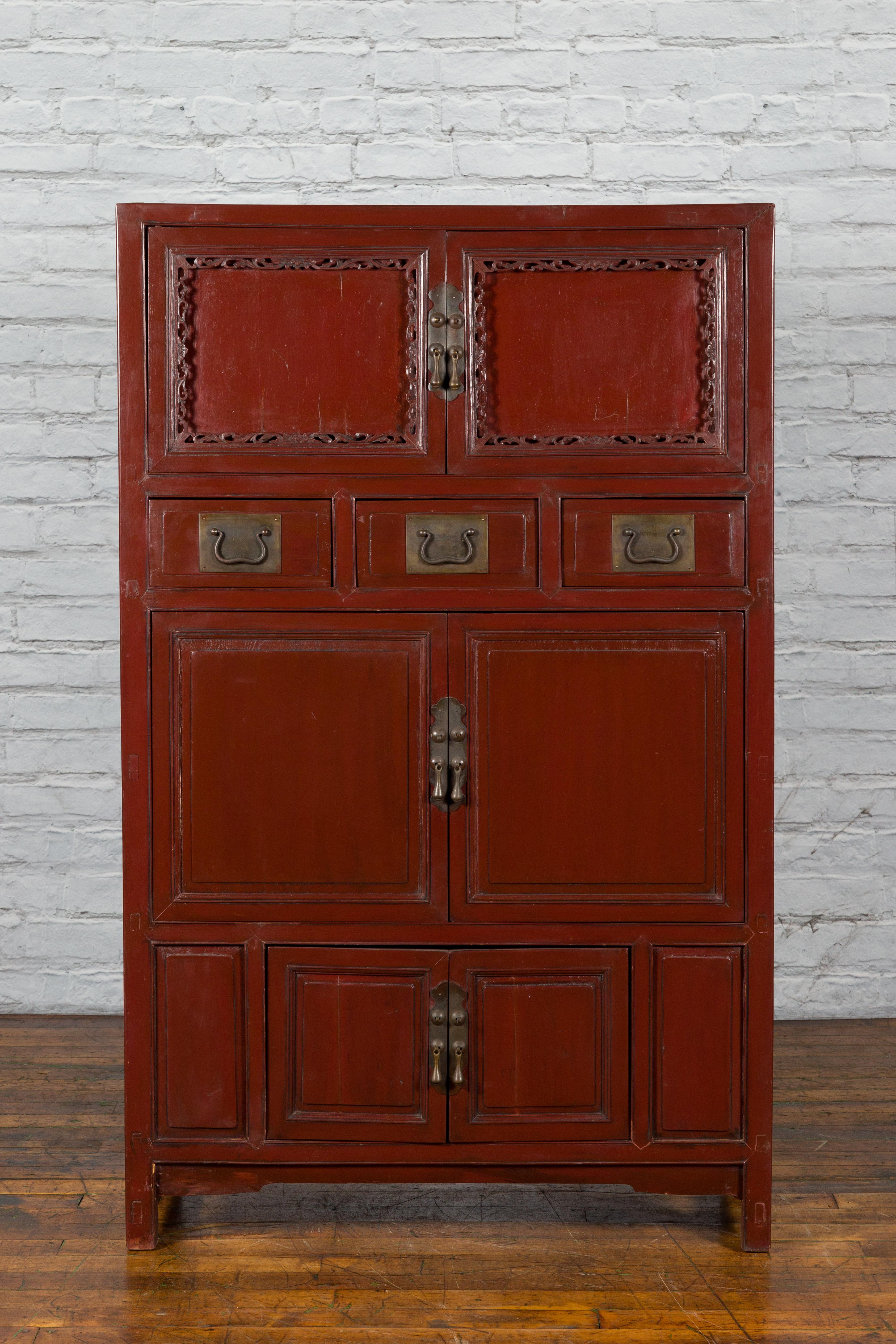 A Chinese Qing dynasty period red lacquer cabinet from the mid 19th century with drawers and doors. Created in China during the Qing Dynasty era, this cabinet features a linear silhouette perfectly complimented by a red lacquer finish. The upper