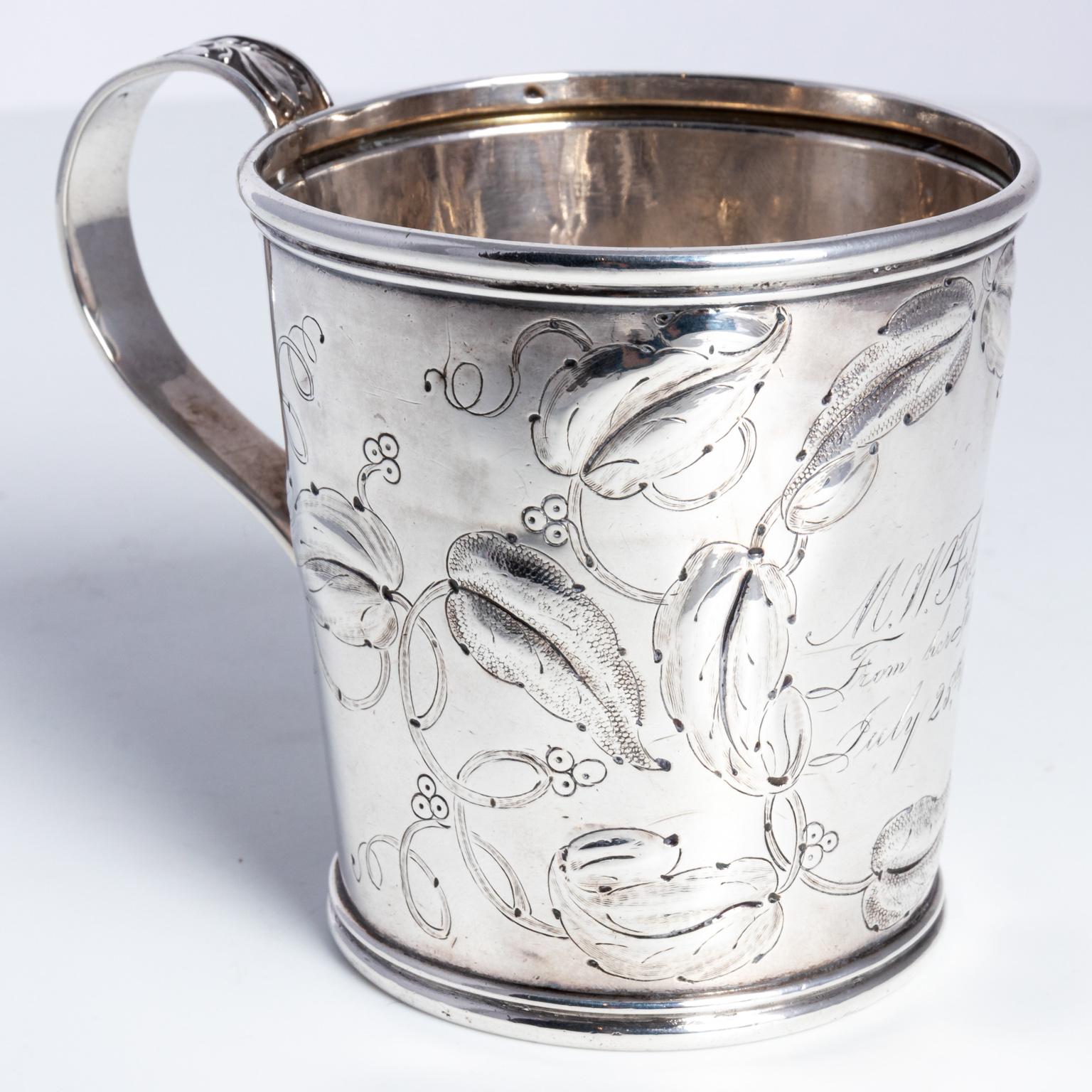 American made baby cup made of coin silver, circa mid-19th century. The engraving on the front is from 1857. It weighs 110.40 grams. The piece is marked on the bottom 