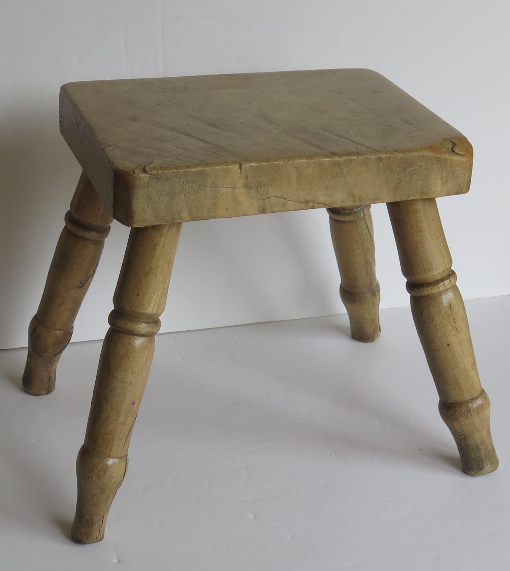 This antique hand-made milking stool or stand is a good example of English Country furniture, made out of sycamore with turned legs and a lovely depth of colour, all dating to the early Victorian period circa 1840.

The thick rectangular top has