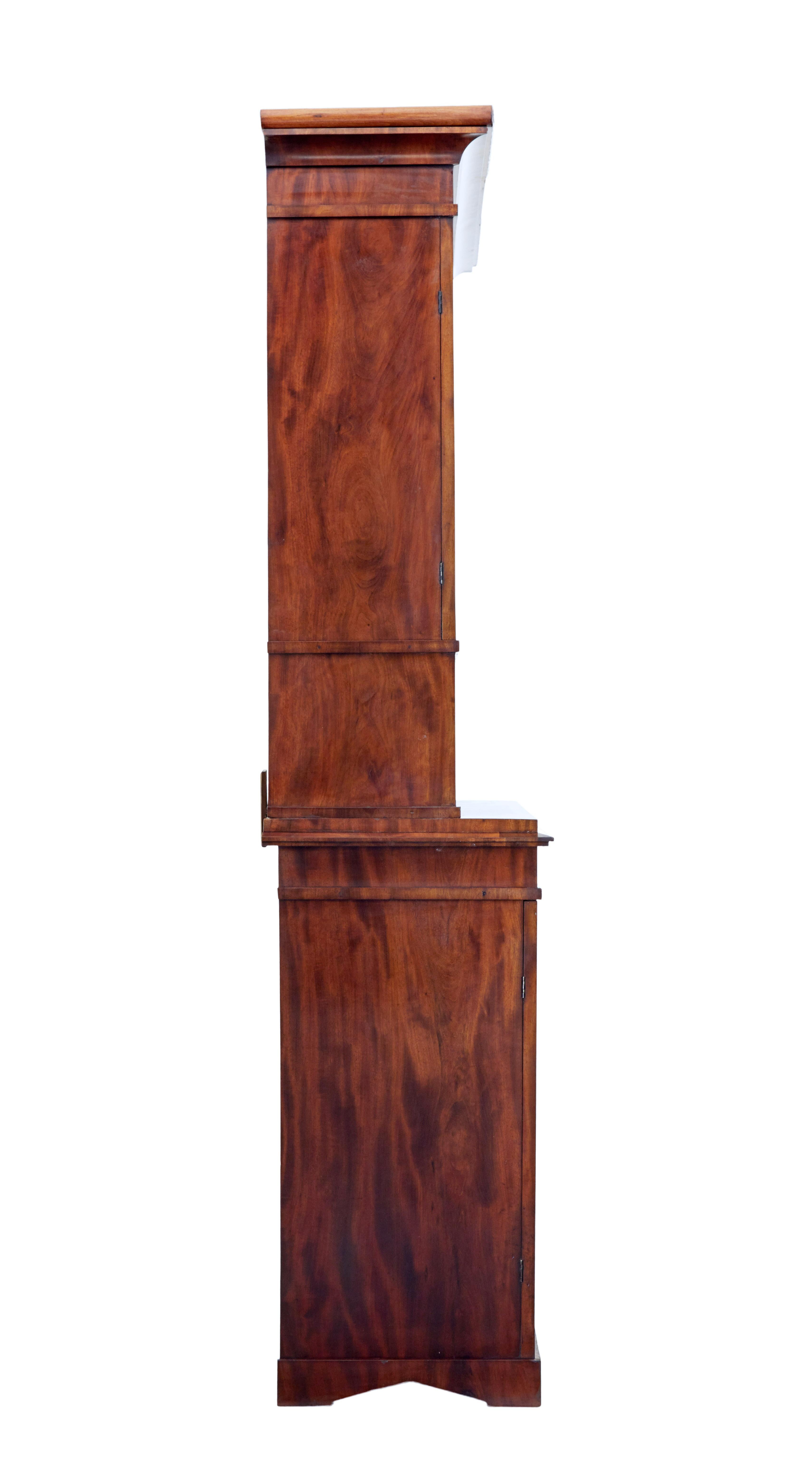 Good quality Danish 2 part tall mahogany cabinet, circa 1860.

Top section with scrolled cornice and applied swags, double doors with shaped panels open to reveal 3 adjustable pine shelves. Below this an open display aperture with further applied