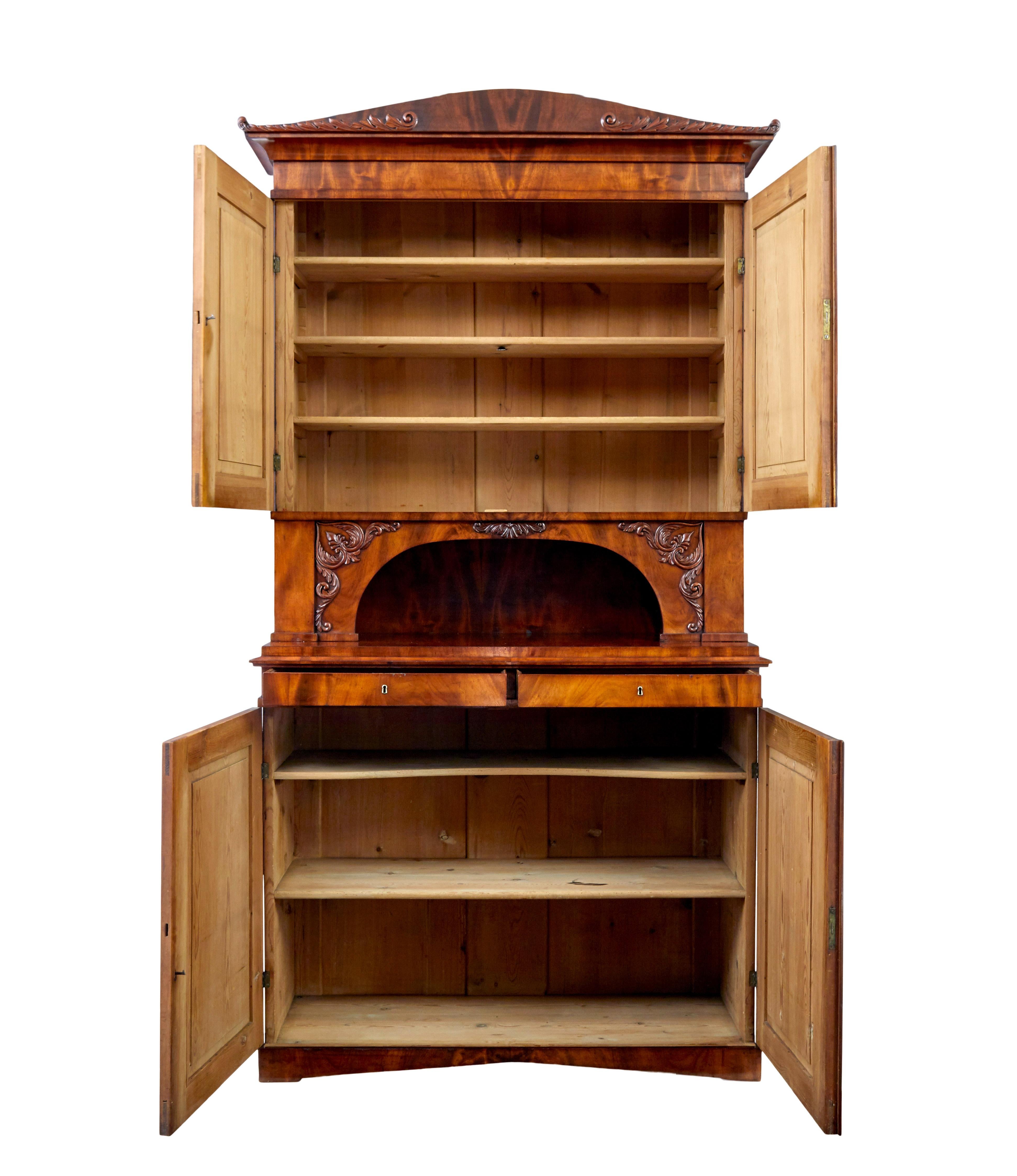Armadio danese di buona qualità in mogano alto in due parti, circa 1860.

Sezione superiore con cornicione a volute e volute applicate, doppie ante con pannelli sagomati che si aprono per rivelare 3 ripiani regolabili in pino.  Al di sotto,