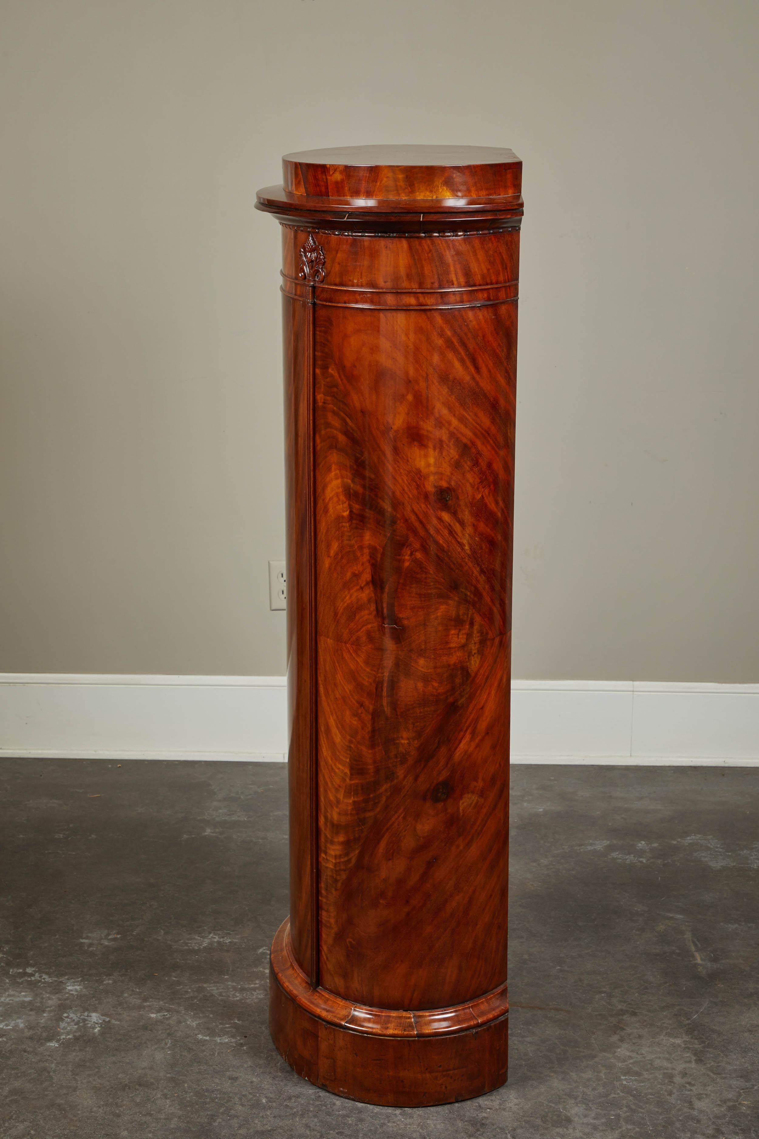A remarkable mid-19th century Danish mahogany pedestal cabinet in the Biedermeier style comprised of mahogany wood and one key hole. This piece was made to showcase a beautiful object or sculpture and yet still maintains a utilitarian use by
