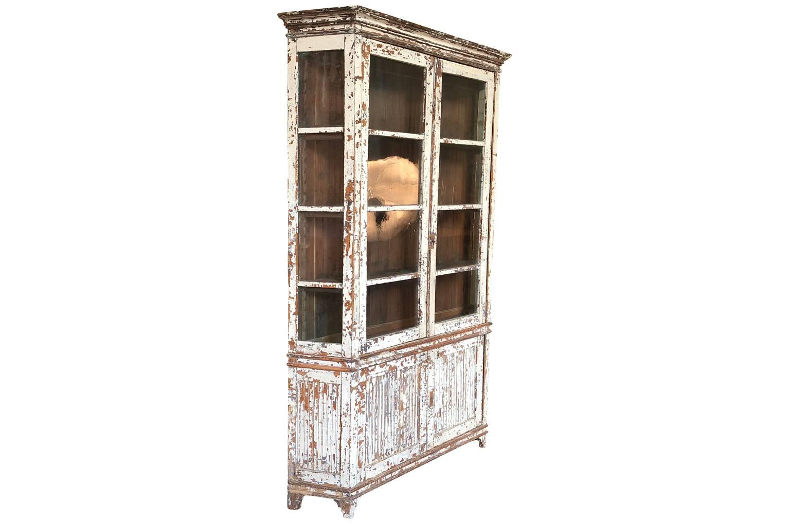 A sensational deux corps bookcase from the South of France. Beautifully constructed with canted sides in painted wood. Terrific narrow depth. A wonderful addition to any kitchen or living area.