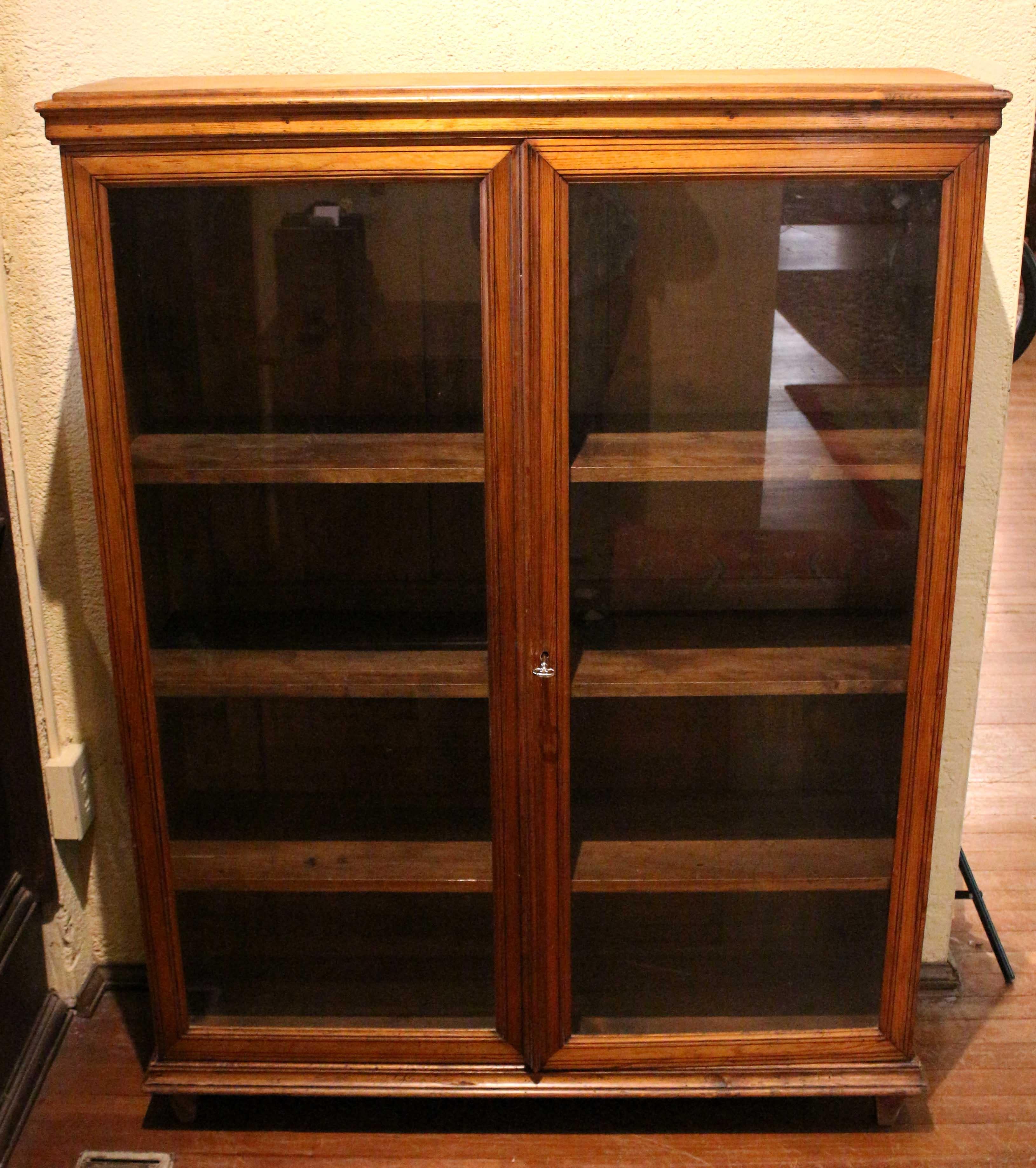 Mid-19th century double glazed door bibliotheque (bookcase), French. Louis Philippe period. Molded top. Ebony line inlaid doors. Plinth molded base raised on short, recessed, simple feet. 41 1/8