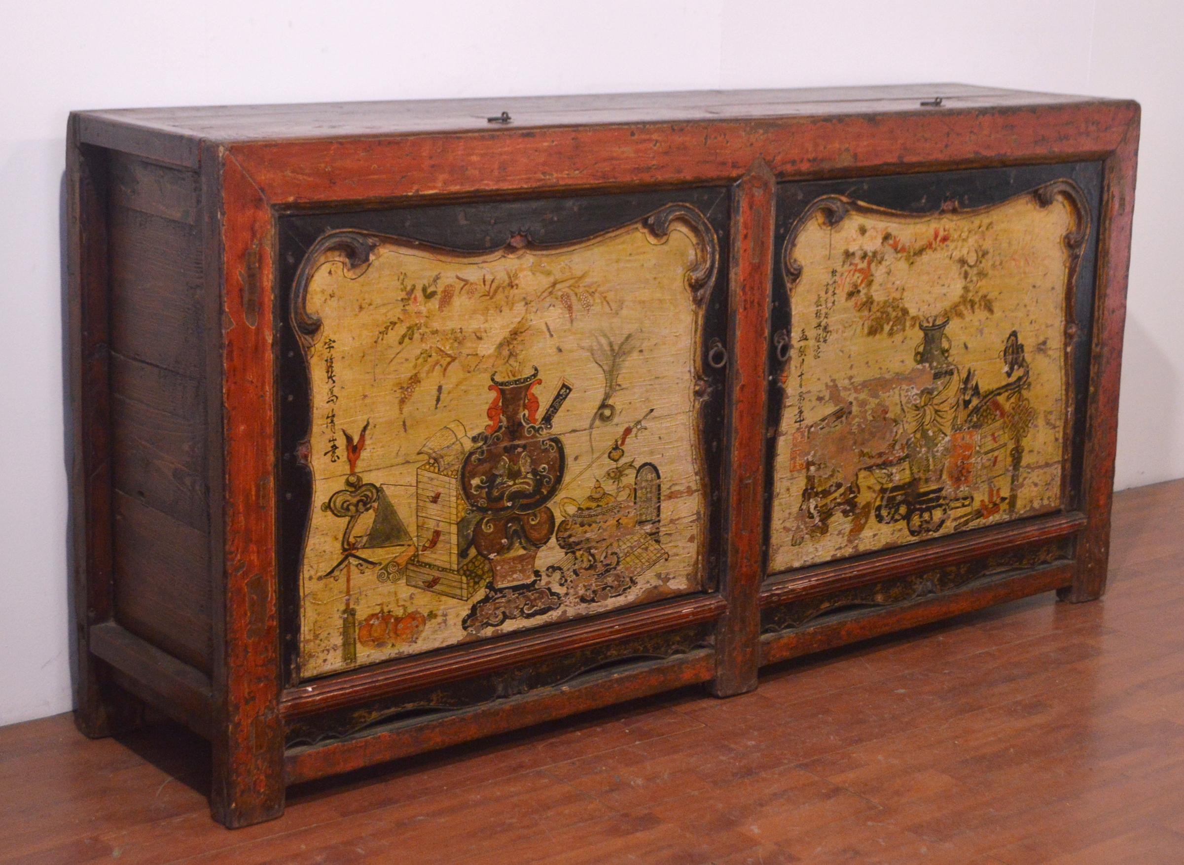 Unique mid 19th century elm Chinese buffet with an amazing red matte finish on the edges. It is composed by 2 openable drawers on the top and 2 big doors in light yellow with hand-carved black decorations. Here, we can find beautiful original