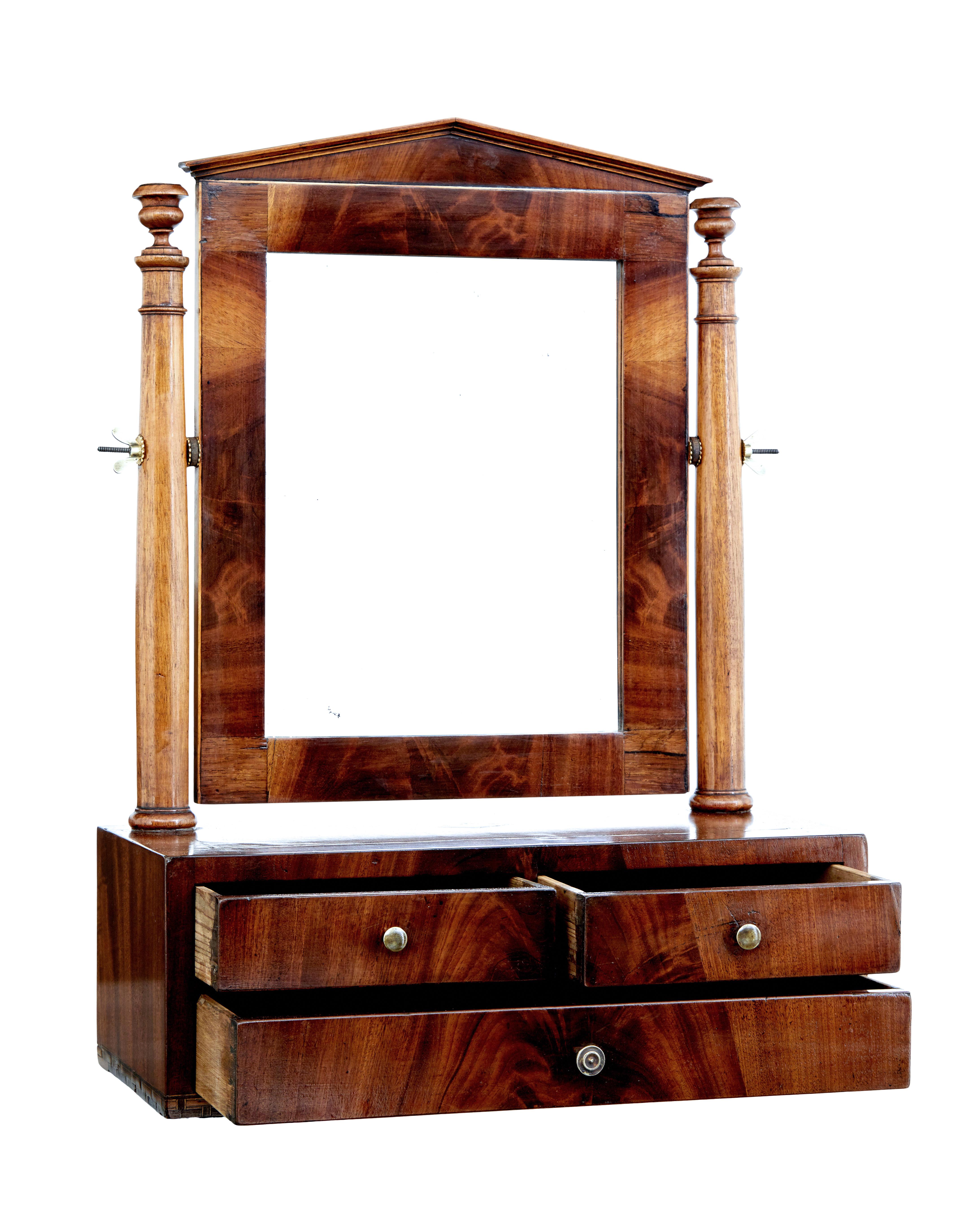 Mid-19th century Empire inlaid mahogany vanity mirror circa 1840.

Characterful mahogany vanity mirror. Typical Empire inspired pediment with the mirror suspended between a pair of turned supports. Rosewood crossbanded top with stringing and
