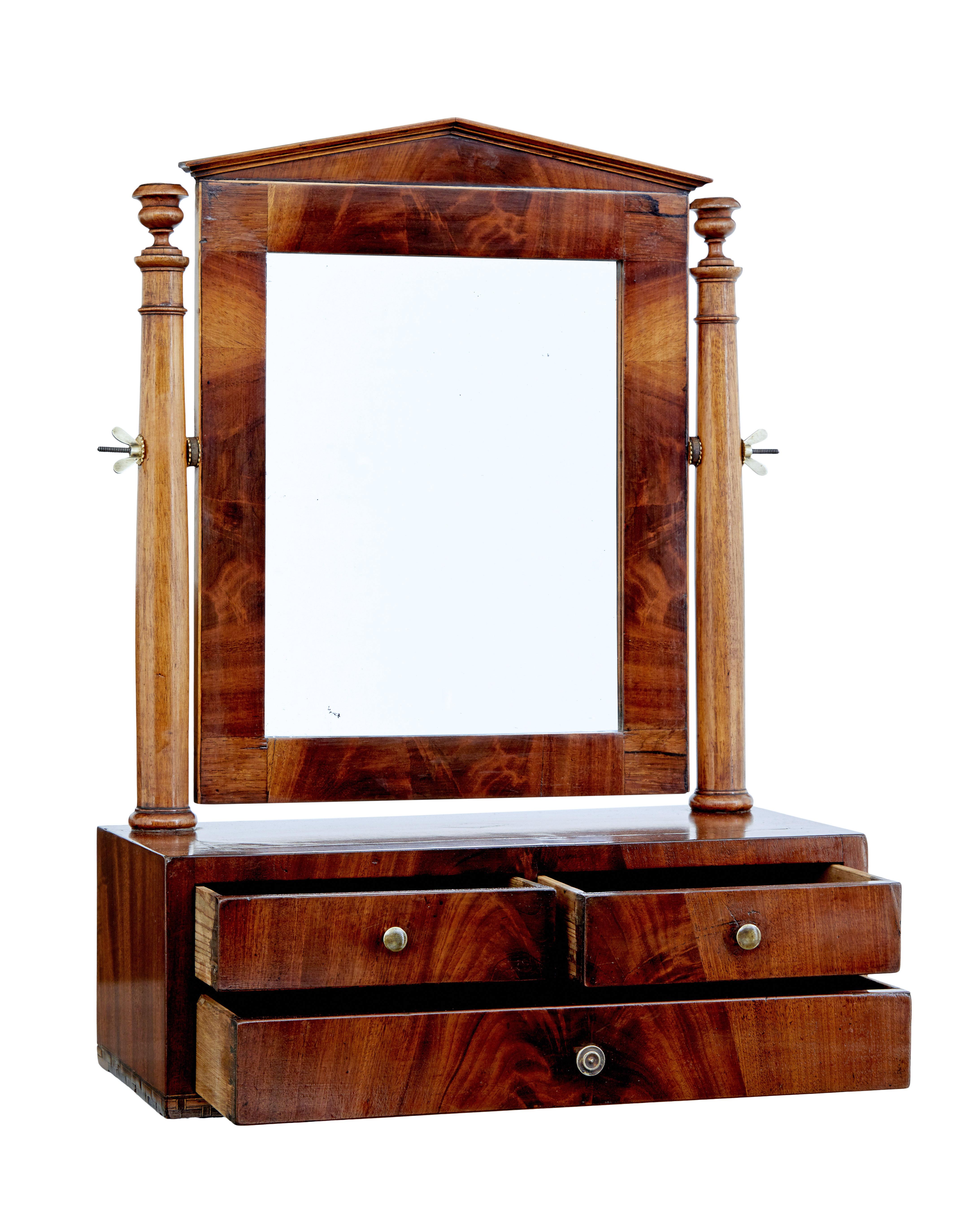 Mid 19th century empire inlaid mahogany vanity mirror, circa 1840.

Characterful mahogany vanity mirror. Typical empire inspired pediment with the mirror suspended between a pair of turned supports. Rosewood crossbanded top with stringing and