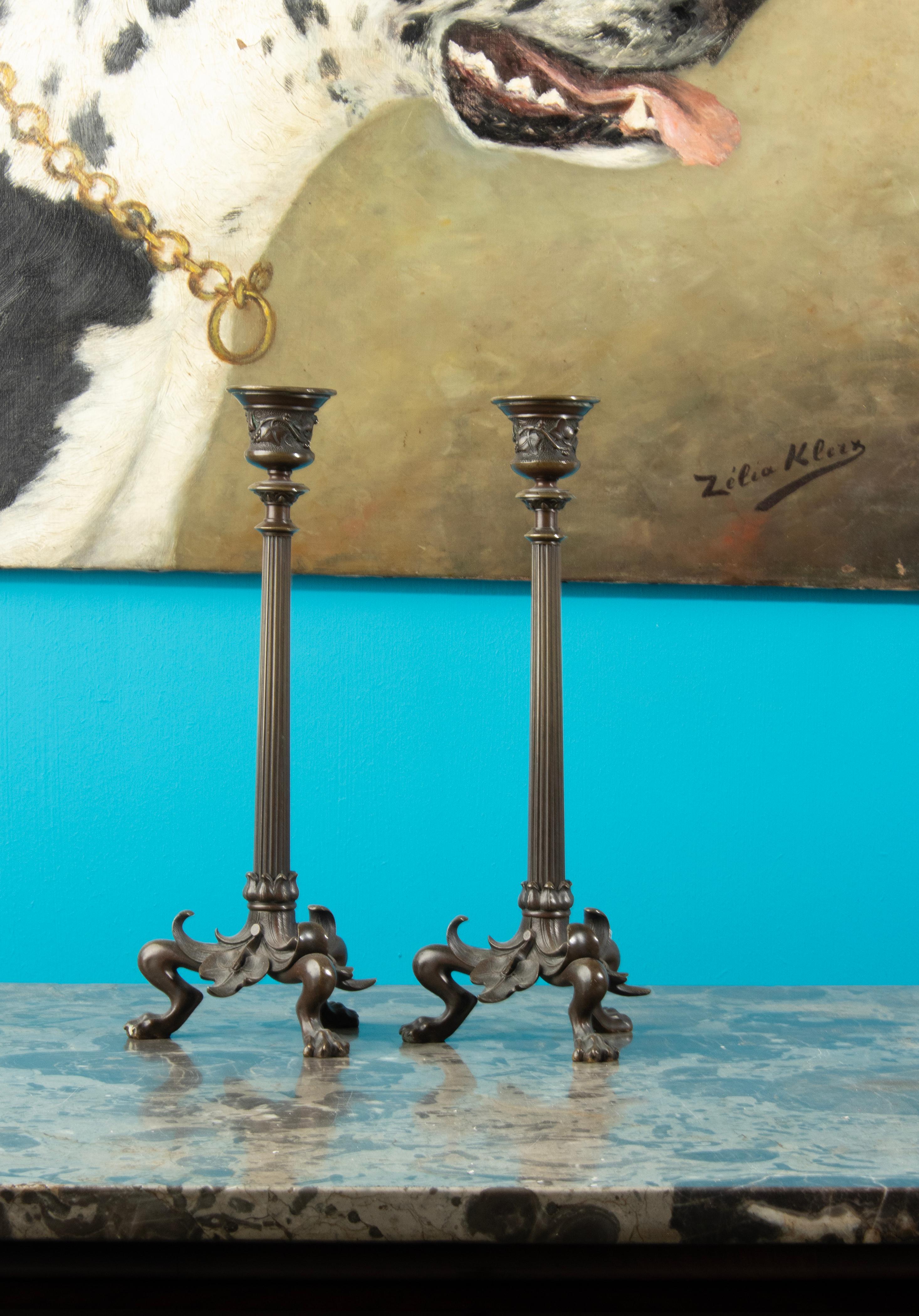 Ein Paar feiner Kerzenleuchter aus braun patinierter Bronze im französischen Empire-Stil aus der Zeit Napoleons III. Eine kannelierte, mit Efeu verzierte Säule erhebt sich auf einem Dreibein mit klauenförmigen Tatzenfüßen. Nach dem Vorbild von