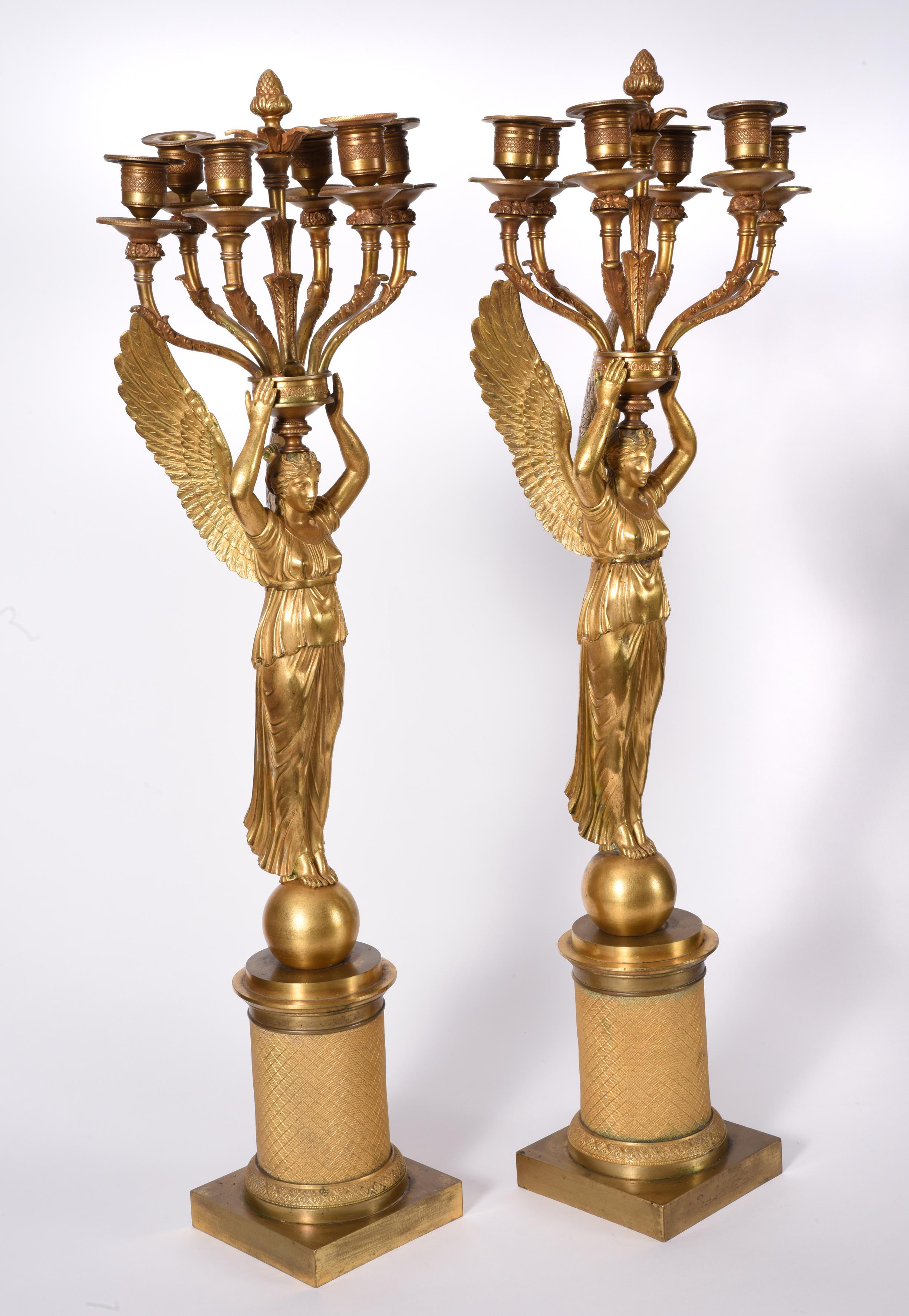 Mid-19th century pair of Empire style gilt bronze six-light candelabras. Each candelabras is in excellent antique condition with minor consistent to age and use. Each candelabras measure about 28 inches high x 8 inches diameter.
 