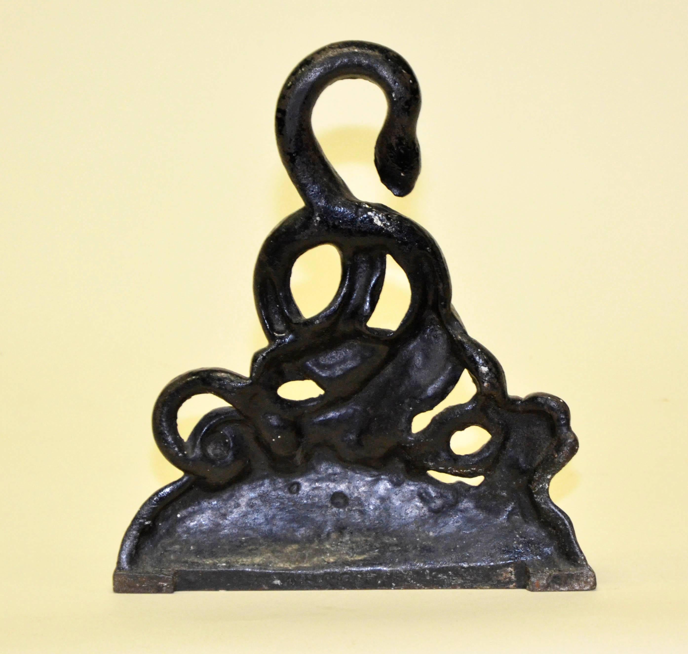 Mid-19th century English Victorian black cast iron door stop with intricate and beautiful snakes motif.