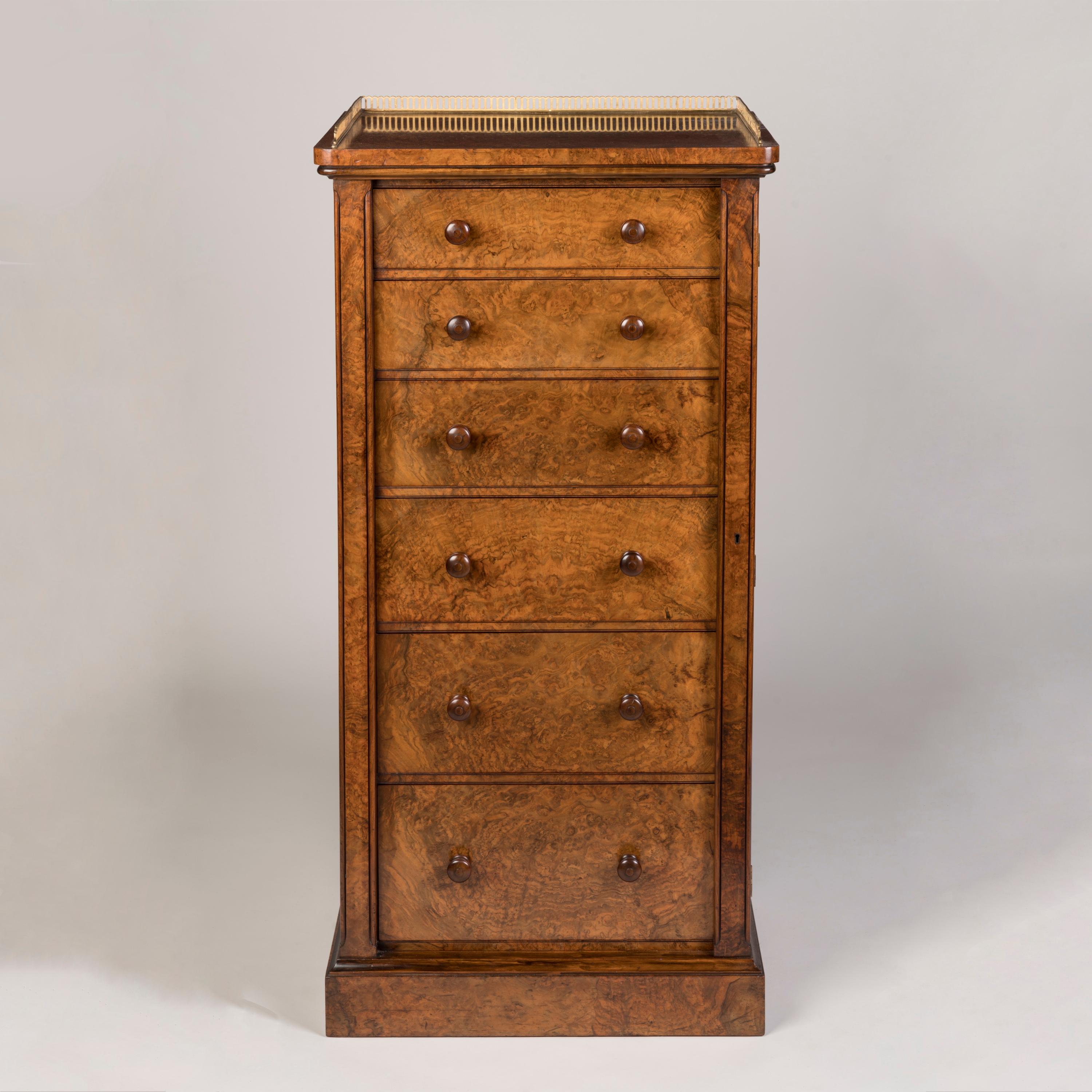 A Burr Walnut Wellington Chest
By Holland & Sons

Constructed using stunning burr walnut veneers, the wellington chest supported on a thumbnail moulded plinth base, an arrangement of six graduated drawers above, each with a pair of turned knob