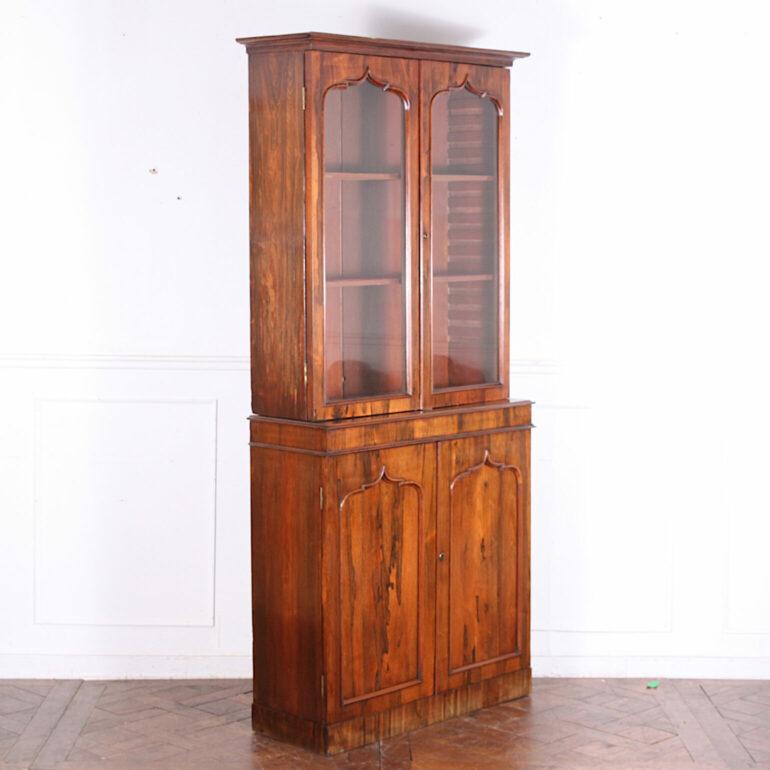 A smaller-scale English mid-Victorian bookcase in exotic wood with Gothic arch profile doors. Adjustable upper shelves and single shelf in cabinet base. C. 1850.

