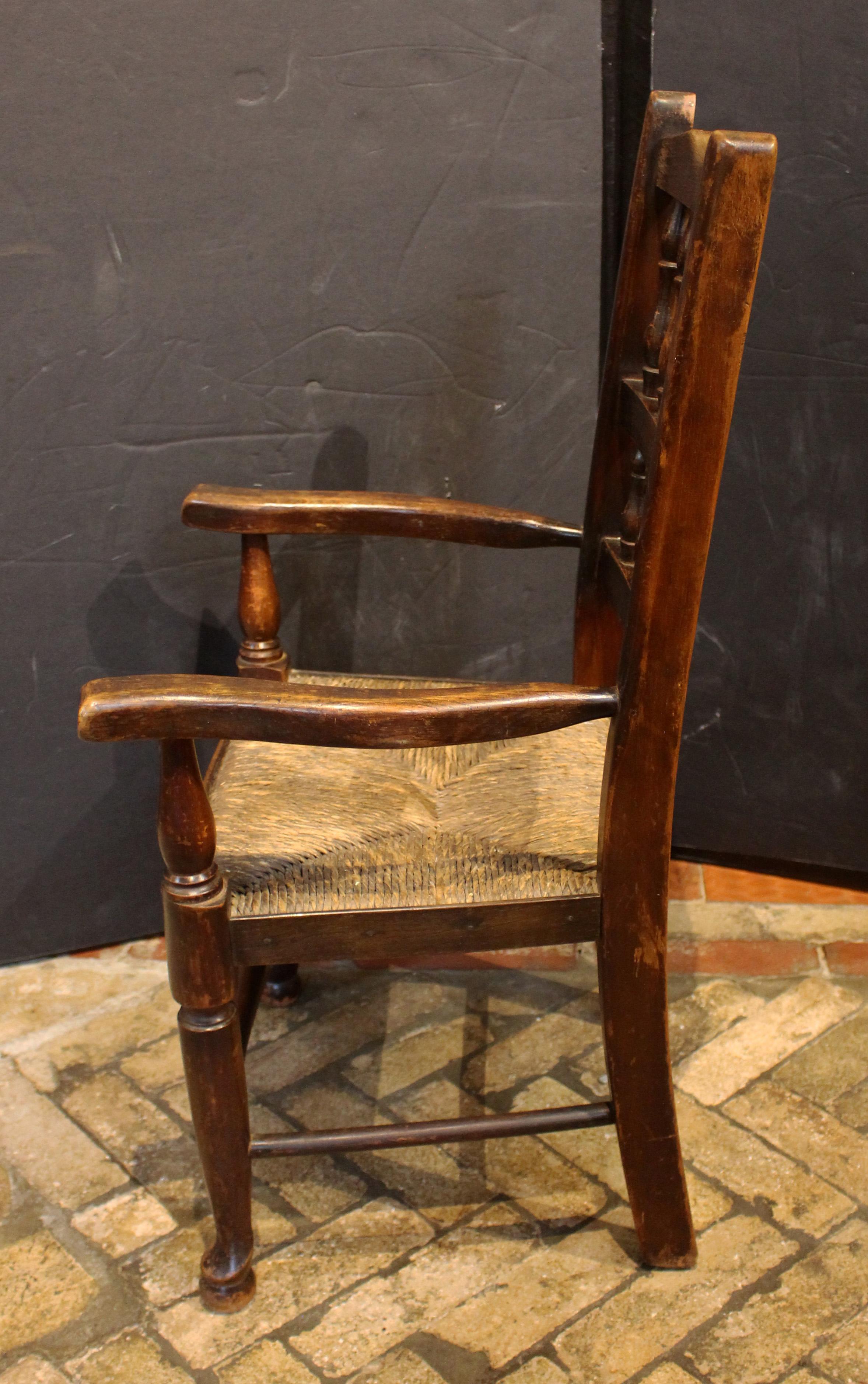 Mid-19th century English Lancashire Child's Arm Chair. Typical Lancashire Queen Anne style. Rarely found child's size. Charming with good vasi-form turnings along the back; shaped arms; pad feet; & turned stretchers. Good old rush in fit
