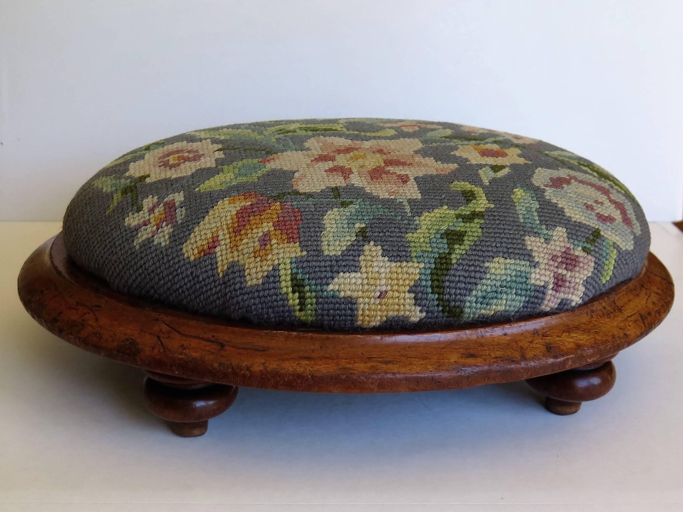 This is a very good example of an English foot stool dating to the mid-19th century of the Early Victorian period, circa 1840-1850.

The stool has an unusual oval shape with a solid walnut frame sitting on four well turned tulip feet. The top is