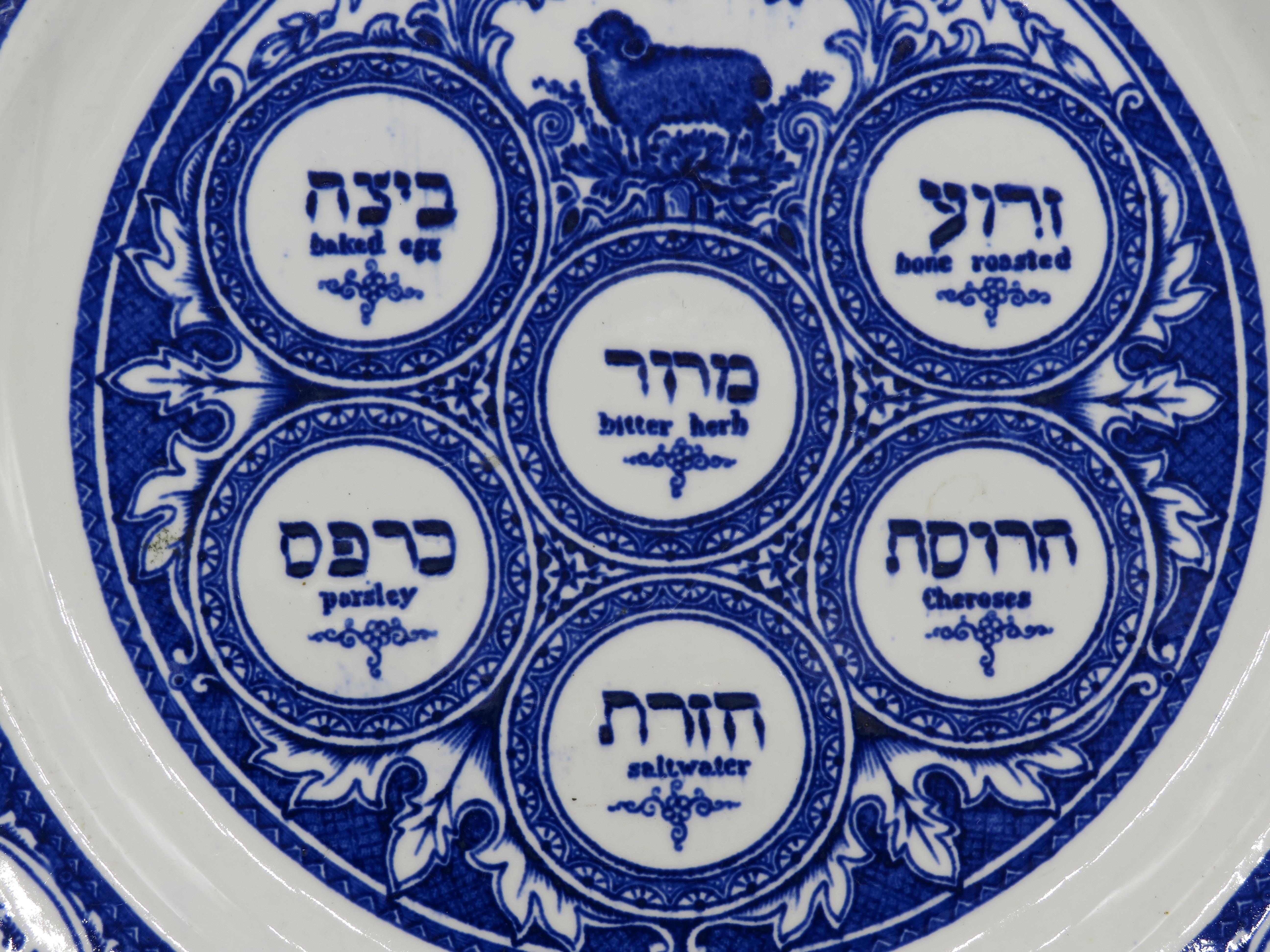 Blue and white pottery Passover plate, by Ridgeways, Staffordshire, England, circa 1850.
In the manner of a traditional Seder plate for Pesach or Passover, decorated with the image of a pascal lamb with small reserves and text in Hebrew and