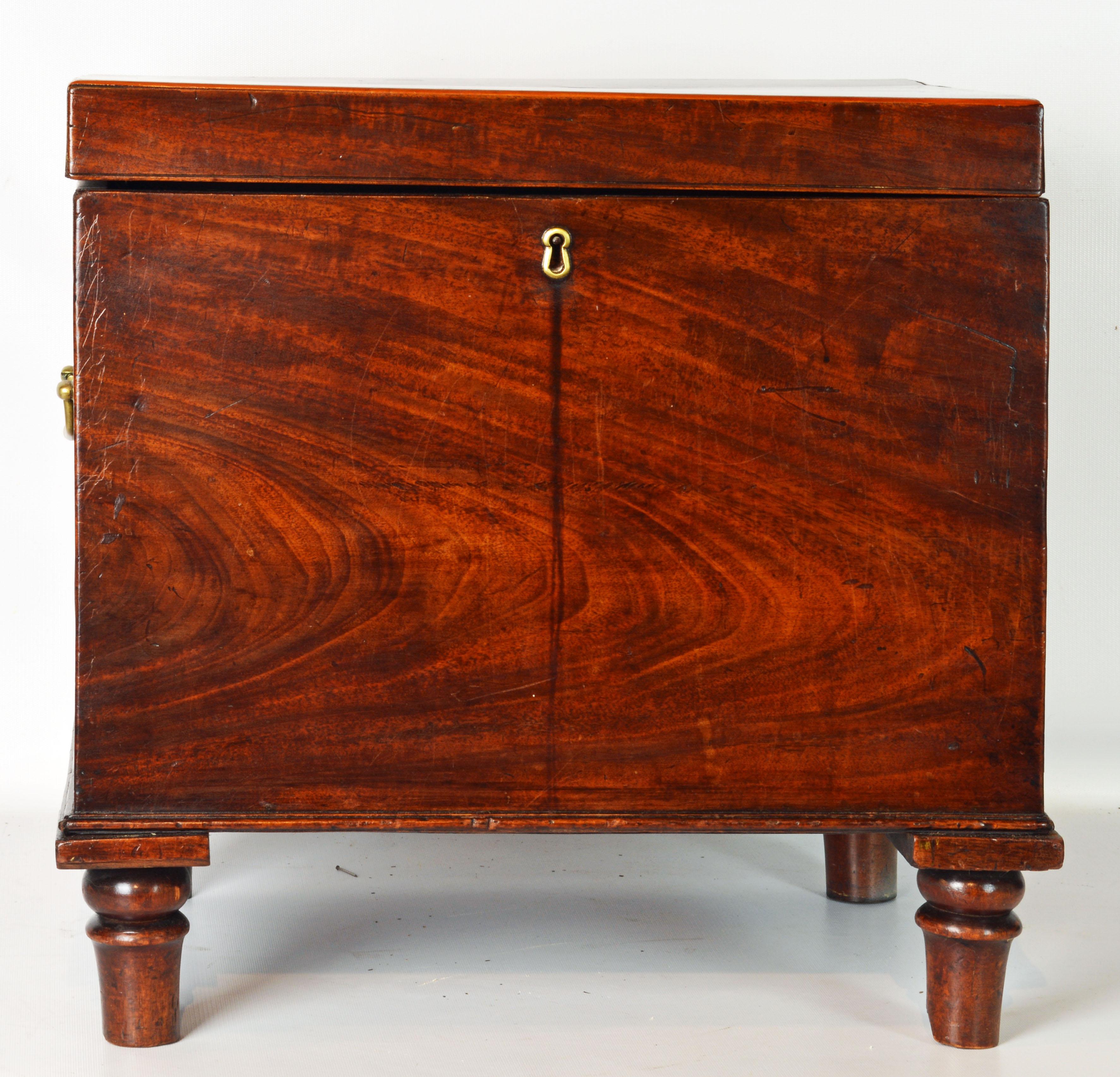 This well proportioned English regency style mahogany cellarette features a top that opens up to an interior retaining its original metal lining. The mahogany veneers are beautifully figured and of a rich warm color. Retaining its original brass