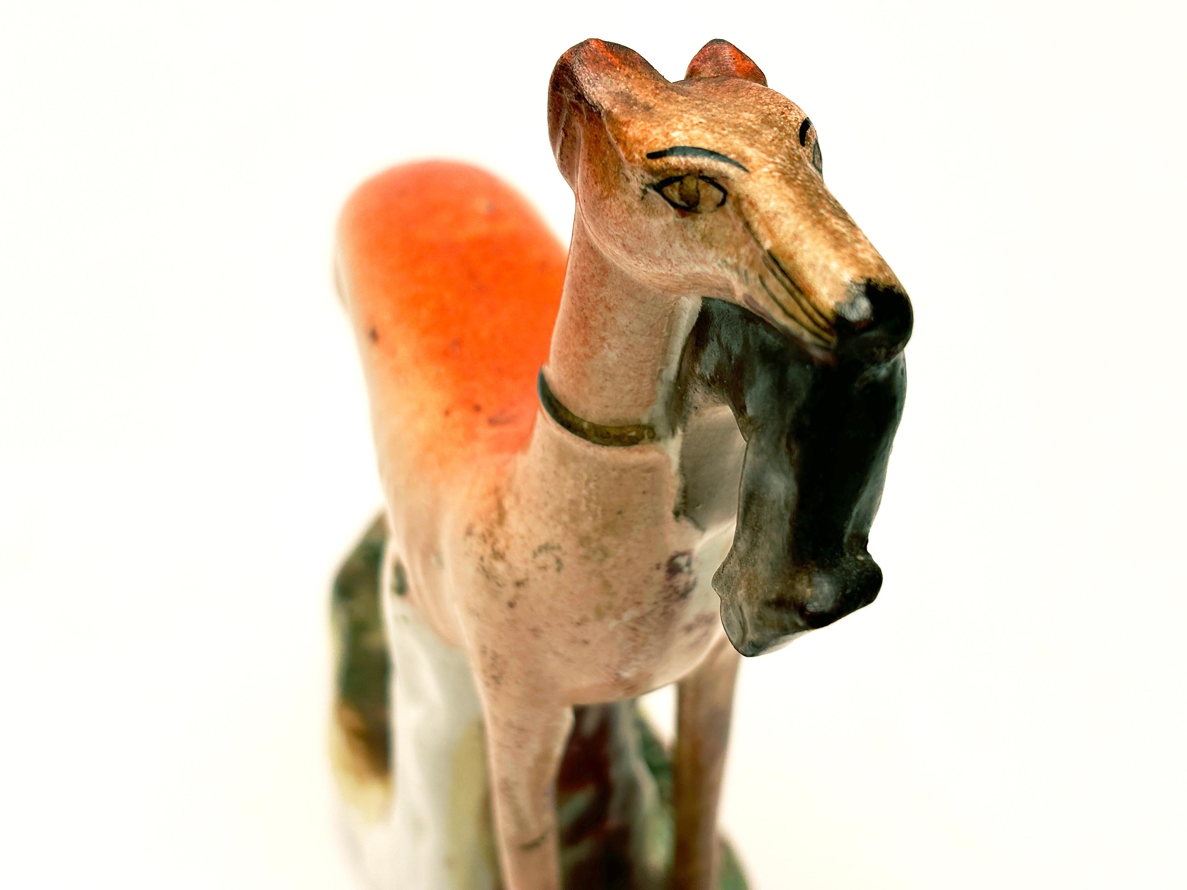 Questa bellissima statuetta di Staffordshire Whippet Greyhound con coniglio è un meraviglioso riflesso di un'epoca passata. Questo maestoso pezzo è stato creato a metà del 1800 con la stessa qualità e le stesse caratteristiche che ci si aspetta da
