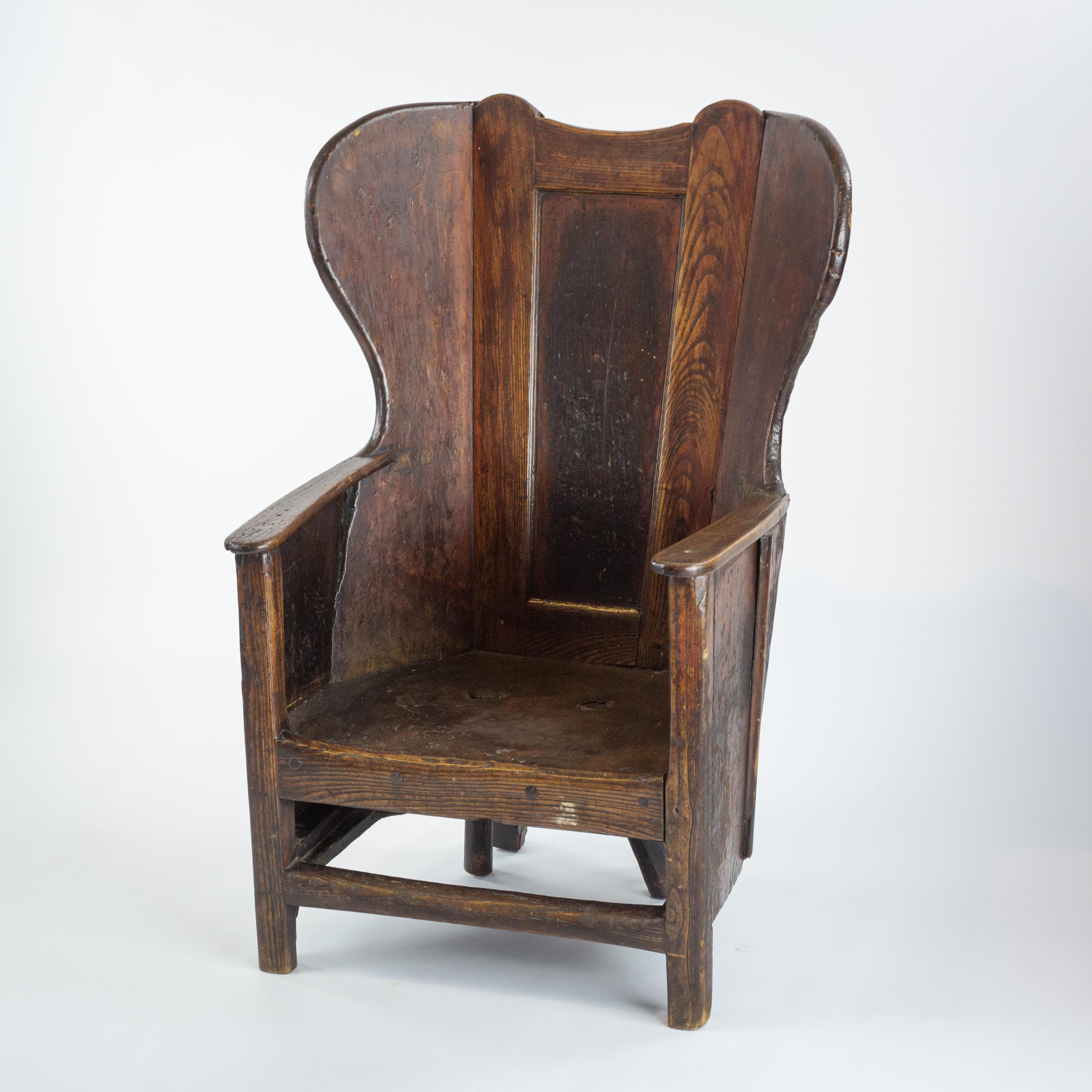 Early 19th Century Westmoreland lambing chair. Originating from the rural landscapes of Cumbria, UK. Designed for comfort and practicality, featuring high back design to provide warmth and shelter from draughts. Exceptional unfettered finish and