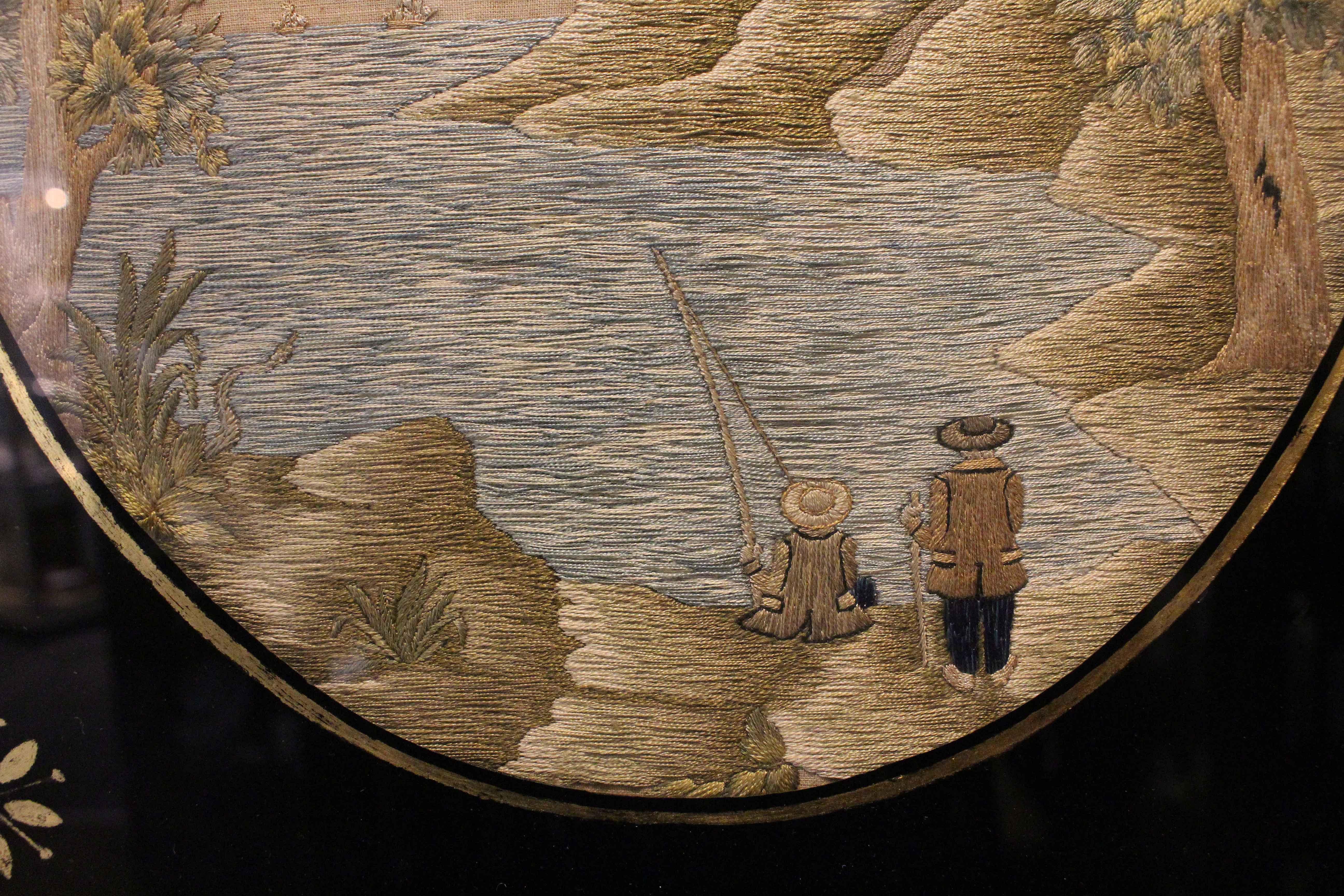 Mid-19th century embroidery needlework in frame with oval eglomise mat, European. Charming ocean inlet scene of 2 fisherman on the bank below the lighthouse with ships in the distance. Soft, muted colors. The frame with edge losses. Frame: 16 1/4