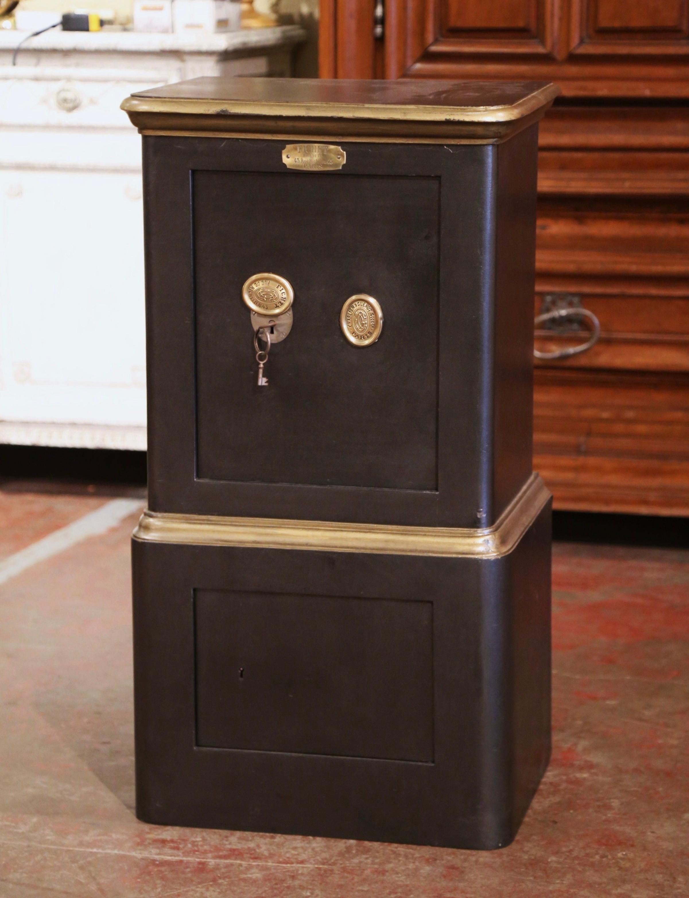 This antique iron safe, with secret combination, was crafted in Paris France, circa 1860. The black and gilt painted safe is dressed with a three bronze medallions (including one covering the key entry), which read: 