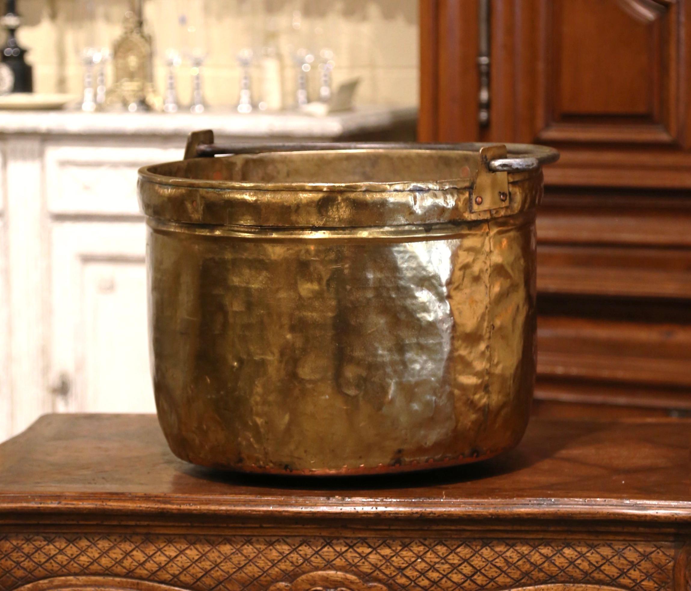 Bring an authentic French countryside touch to your kitchen with this large antique kindling pot. Crafted in Normandy, France, circa 1870, the important cache pot is round in shape and dressed with a wrought iron handle attached with rivets. The
