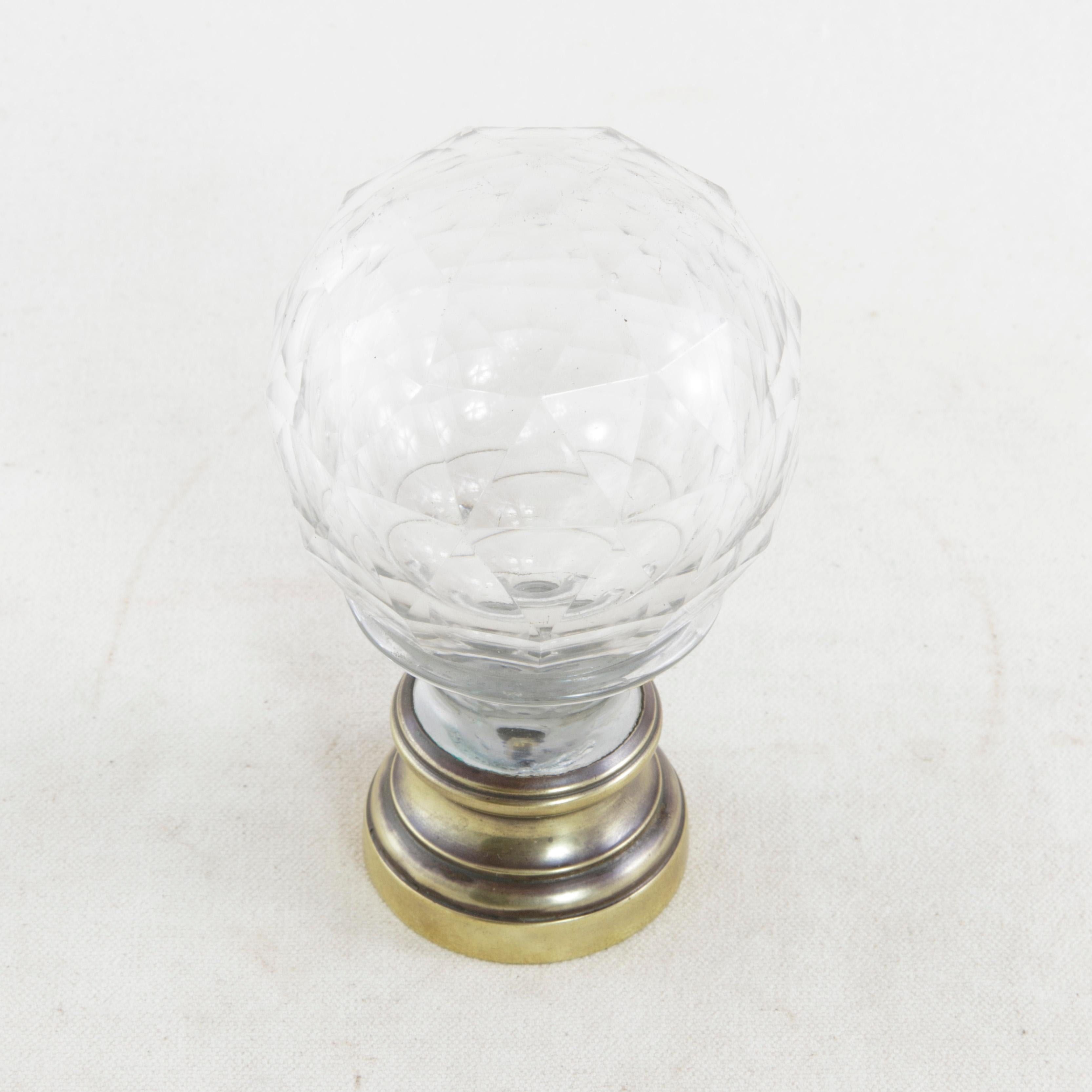 This mid-19nth century Napoleon III period staircase finial features a multifaceted crystal ball mounted on a bronze base. The plate underneath the bronze base is threaded to accommodate a long screw, allowing it to be affixed to a staircase