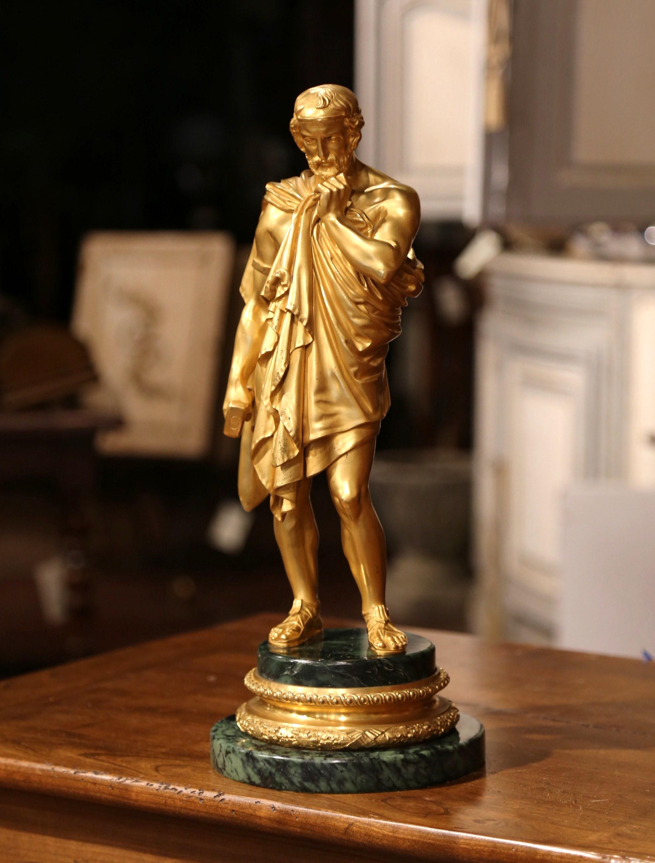 This important gilt bronze sculpture on marble was created in France, circa 1850. The tall bronze doré statue stands on a round green marble base and features an ancient Roman marble sculpture sculptor wearing toga dress and sandals, and holding a