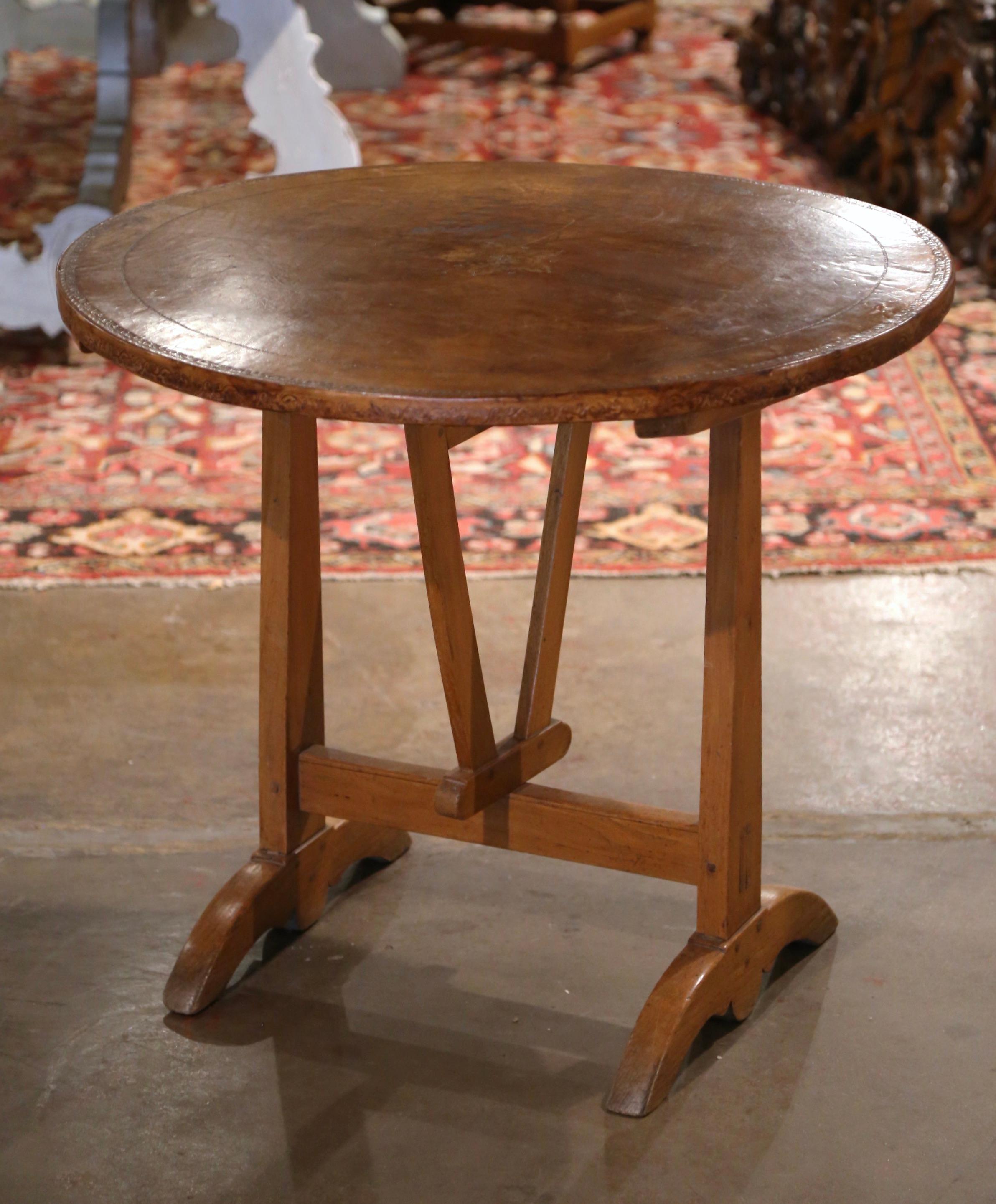 Served your favorite Cab or Bordeaux in style on this antique wine tasting table! Crafted in the Burgundy region of France circa 1870, the table stands on a wedge form trestle base and rotating V shape stretcher, over arched feet; the top is dressed