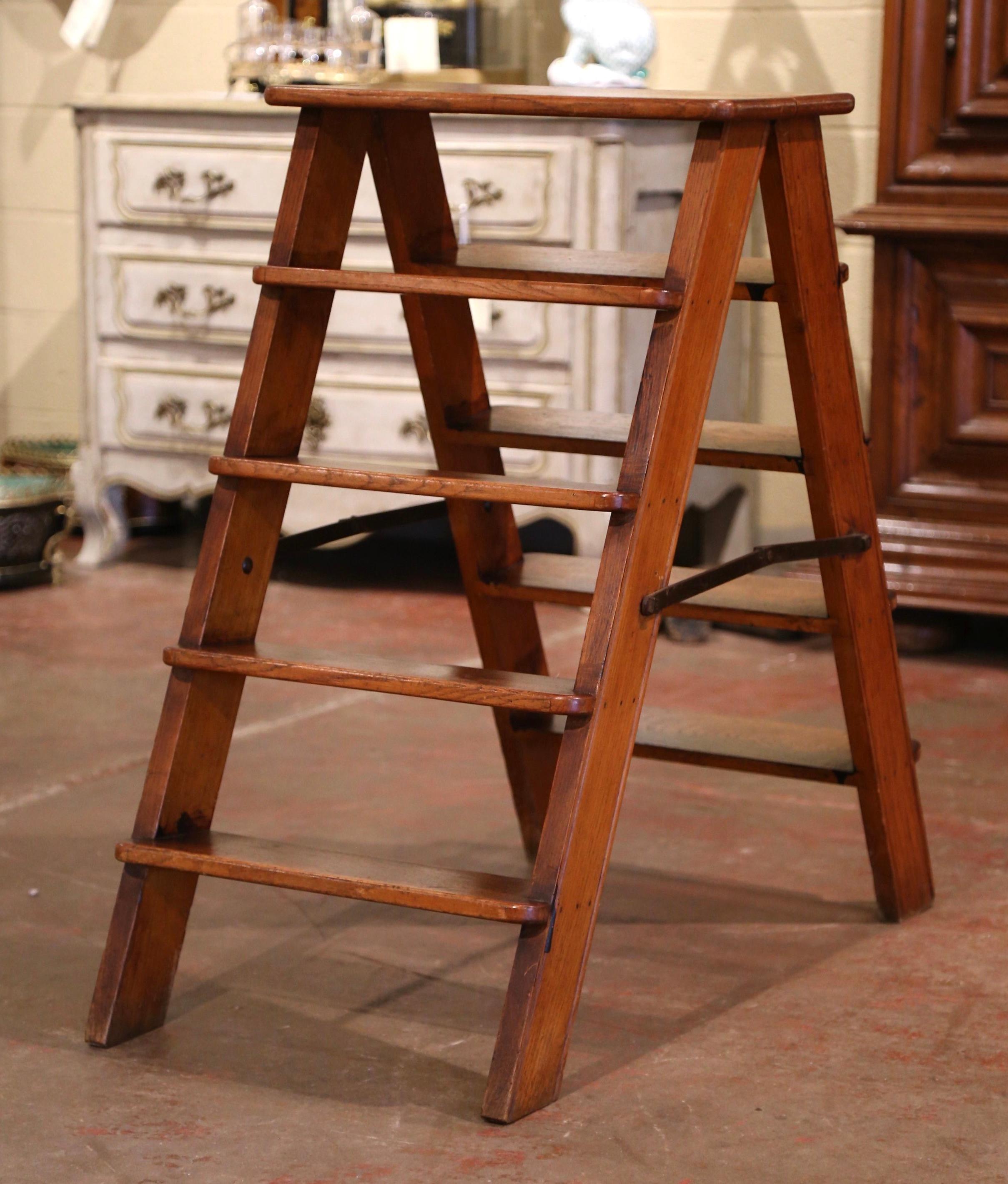 This elegant antique step ladder was created in France, circa 1850. Made of solid oak and folding iron mechanism, the sturdy ladder features four steps on both sides and a flat joined step at the top. Practical and useful, the ladder can folded and