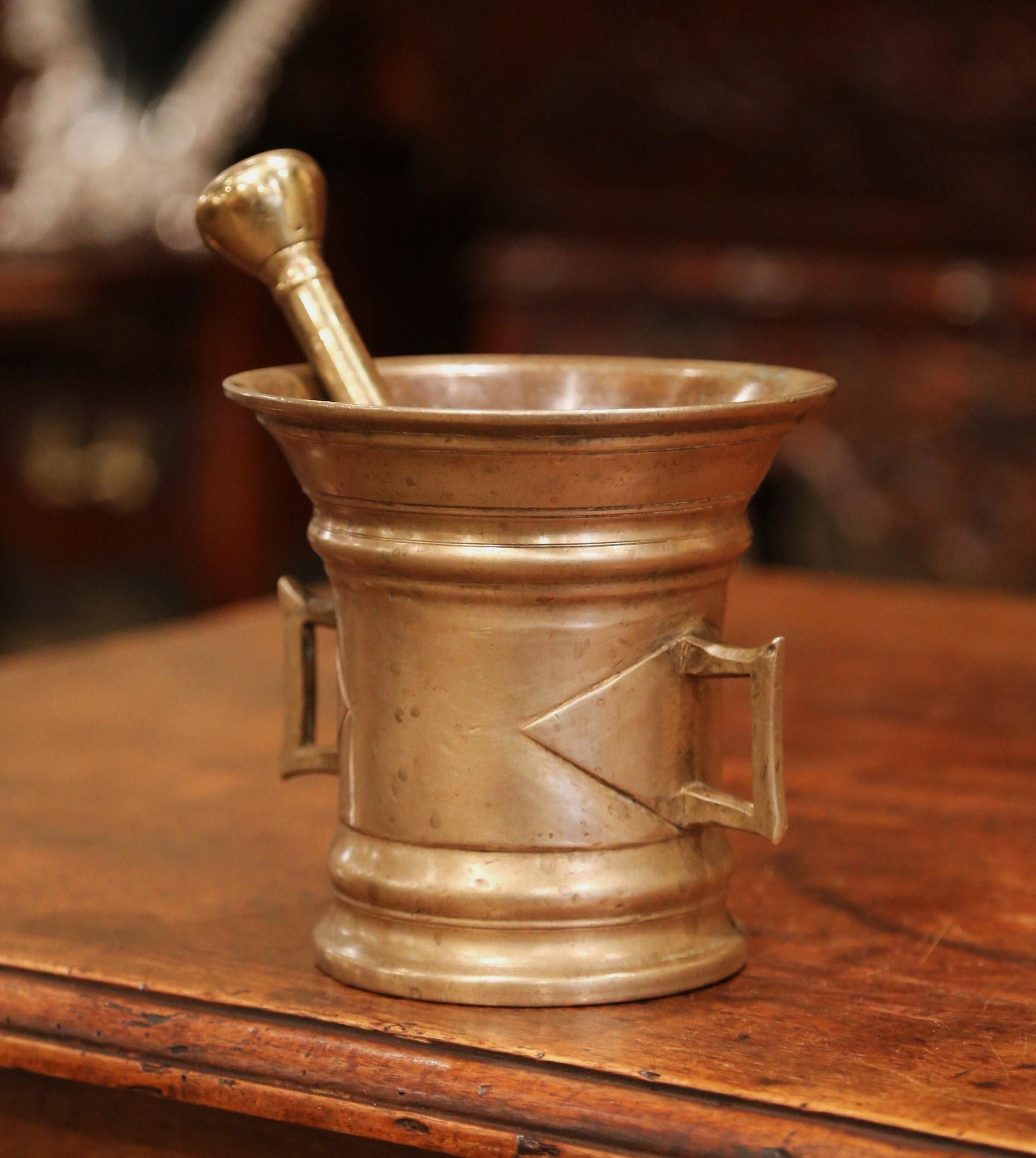 Grind spices in your kitchen with this beautifully carved, antique mortar. Crafted in France circa 1850, the bronze bowl is round in shape; the decorative piece features two side handles and is embellished with geometric design. The kitchen