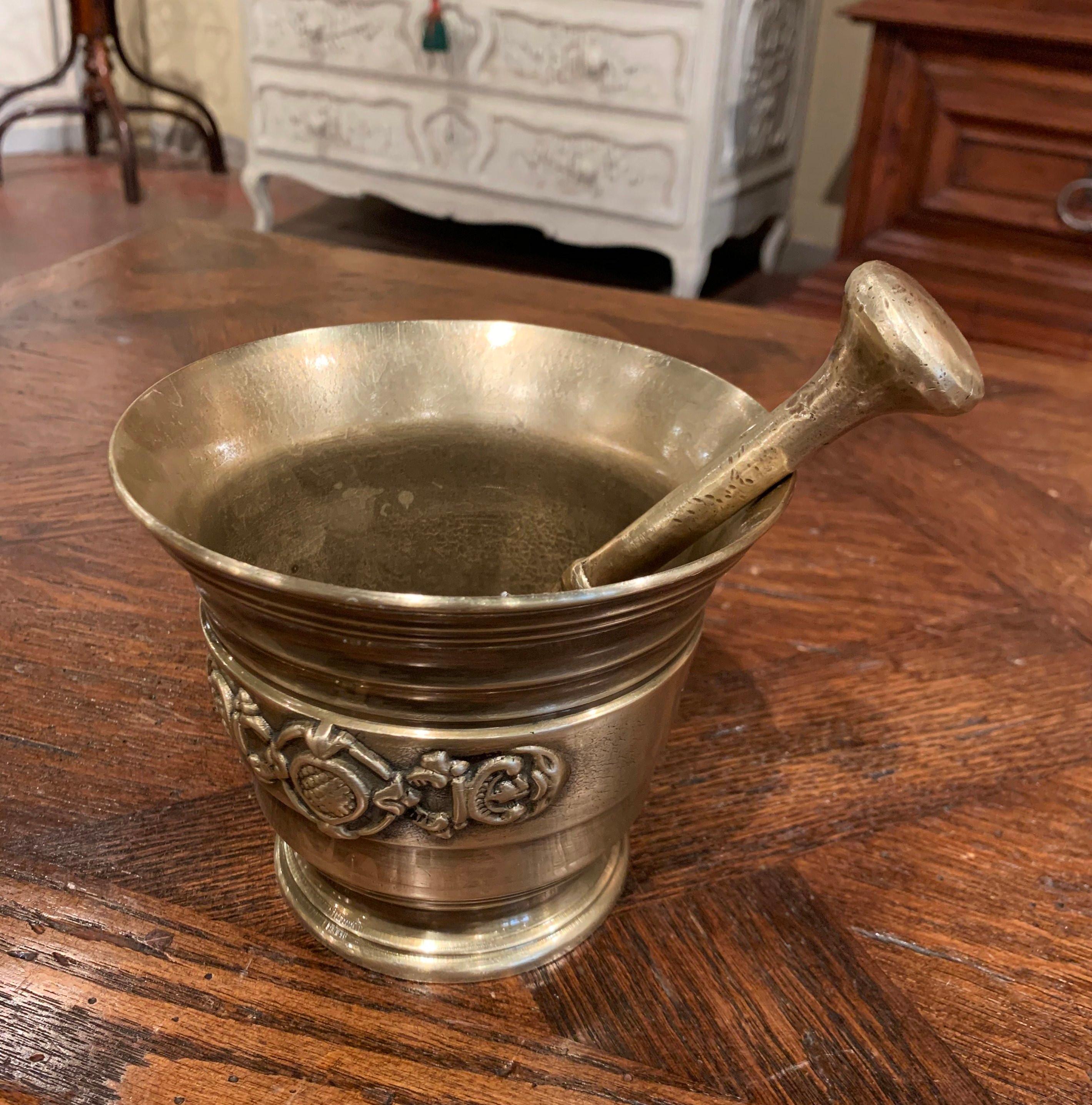 Grind spices in your kitchen with this beautifully carved, antique mortar. Crafted in France circa 1860, and made of bronze, the decorative bowl is round in shape and embellished with floral motifs in high relief. The kitchen essential is in