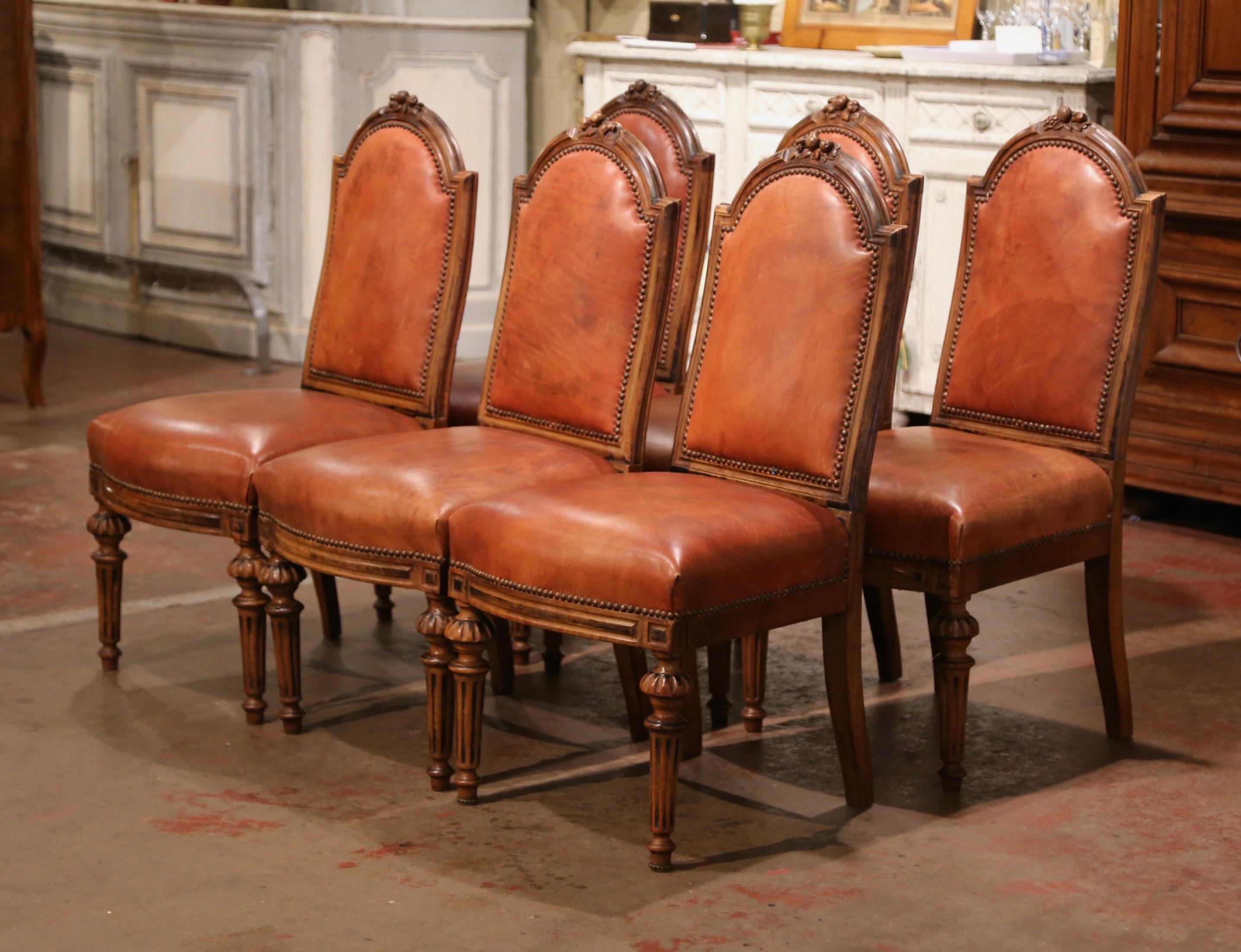 Dress a dining table or breakfast room with this elegant suite of antique chairs. Crafted in France, circa 1870, each side chair stands on tapered and fluted legs, decorated with turned motifs at the shoulder. Each chair has an arched back